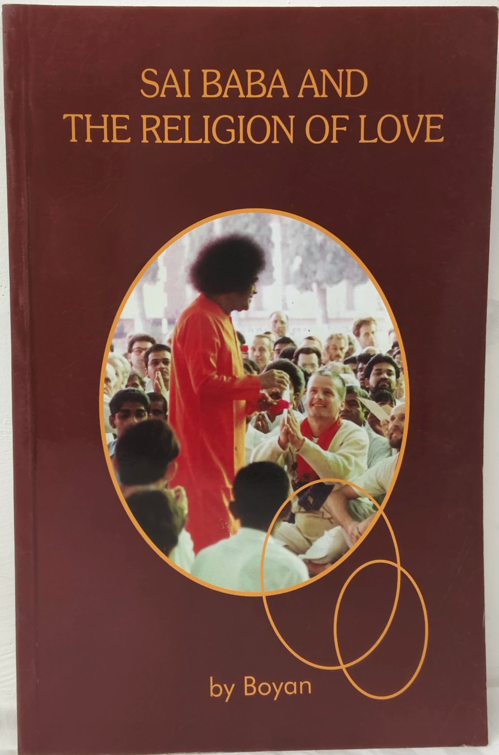 Paperback book titled 'Sai Baba and The Religion of Love' with photo of Sai Baba and devotees
