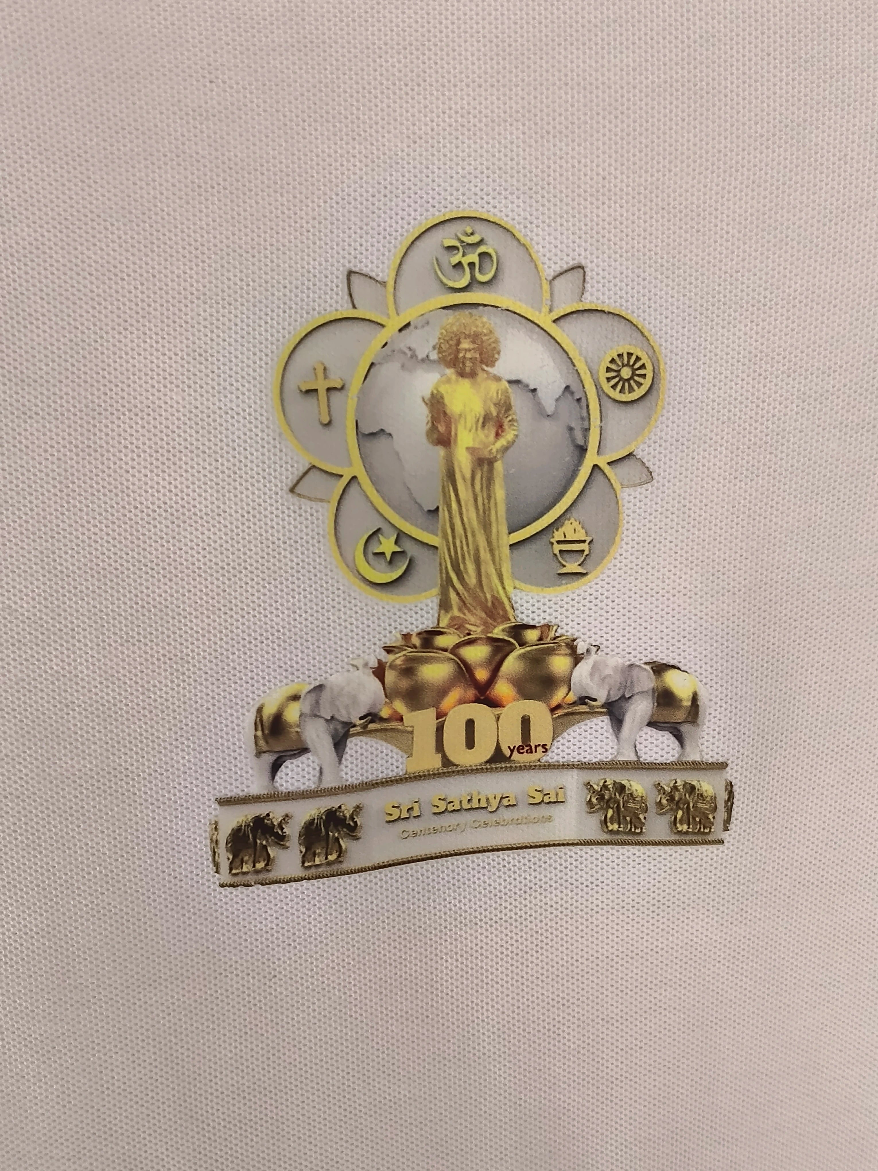 Close-up of men's polo T-shirt with Sri Sathya Sai centenary emblem on light fabric