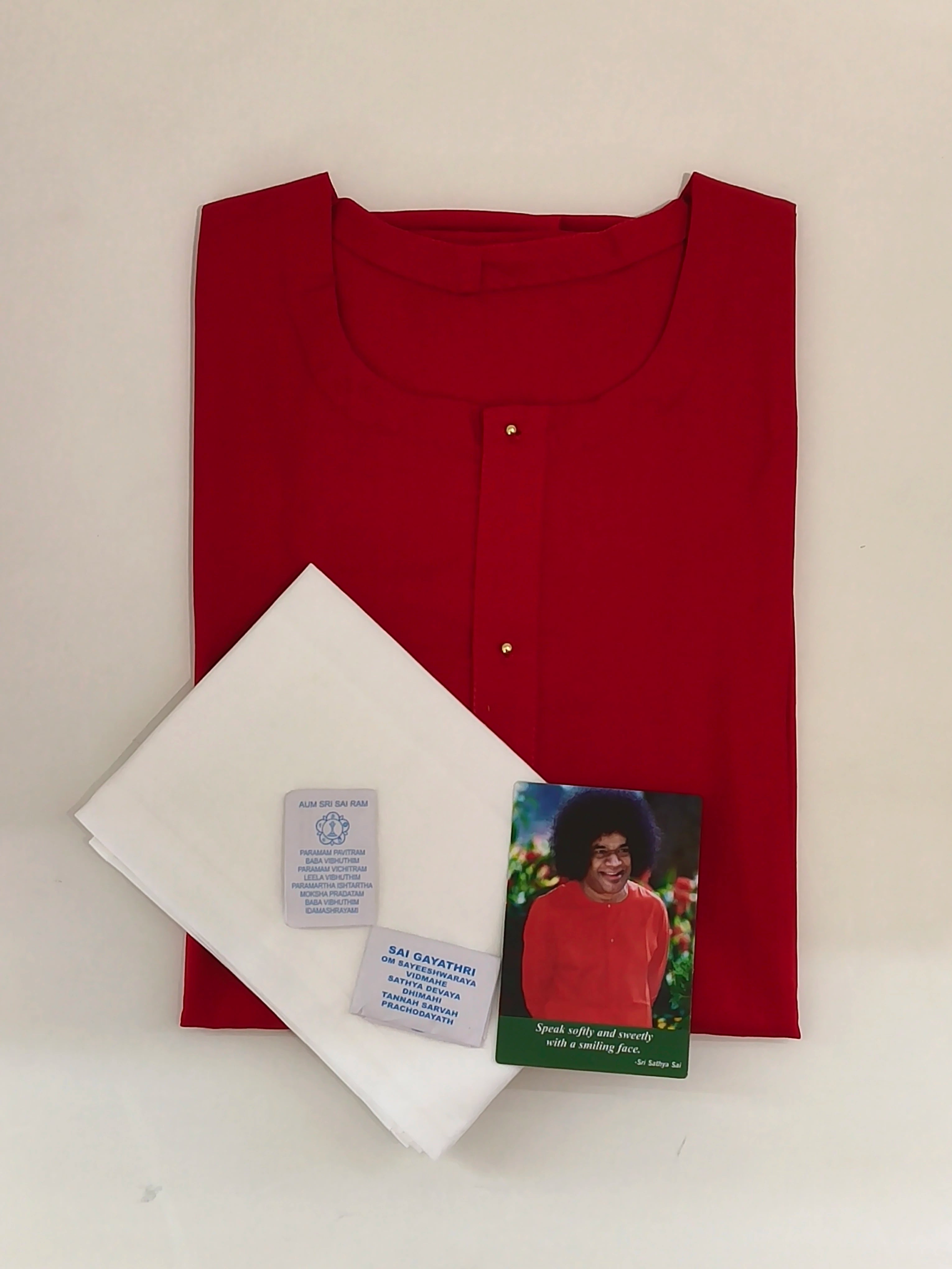 Folded red Swamy robe with two white napkins and Sai Baba prayer cards
