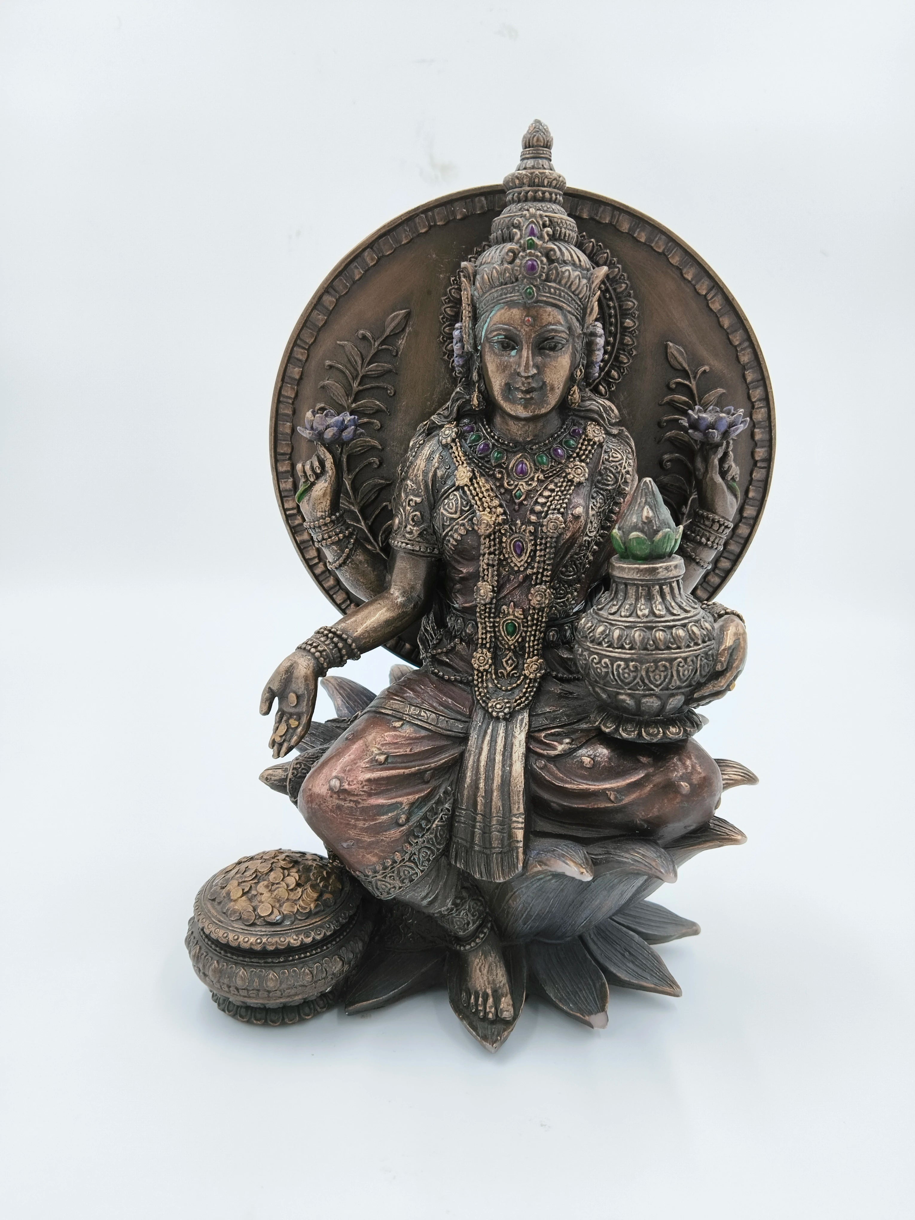 Decorative metallic fiber Lakshmi statue adorned with jewels, seated on lotus