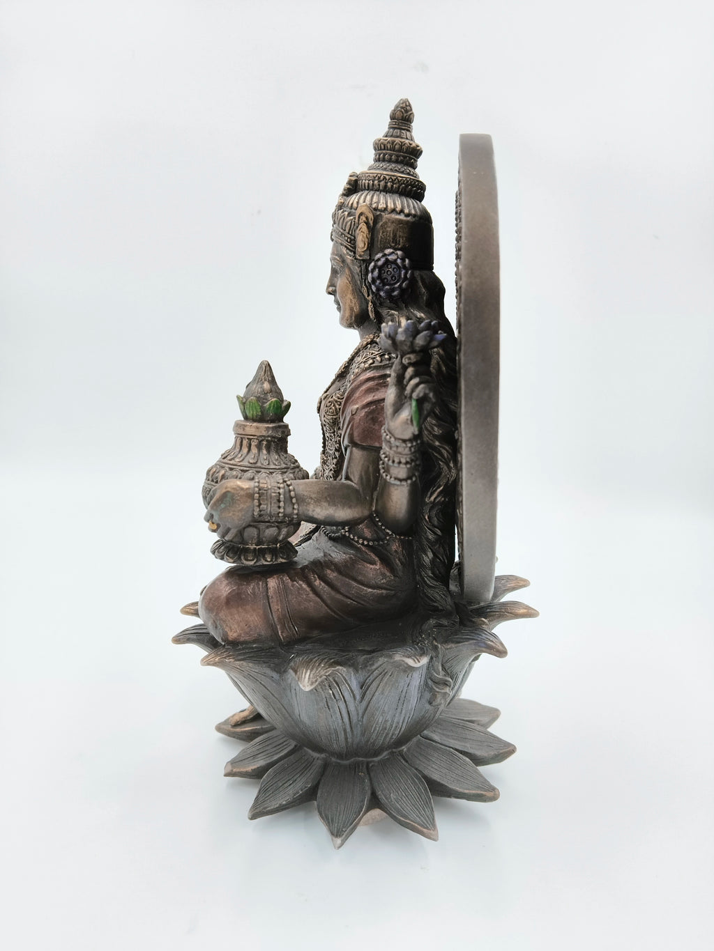Side view of metallic fiber sculpture of Lakshmi seated on a lotus flower