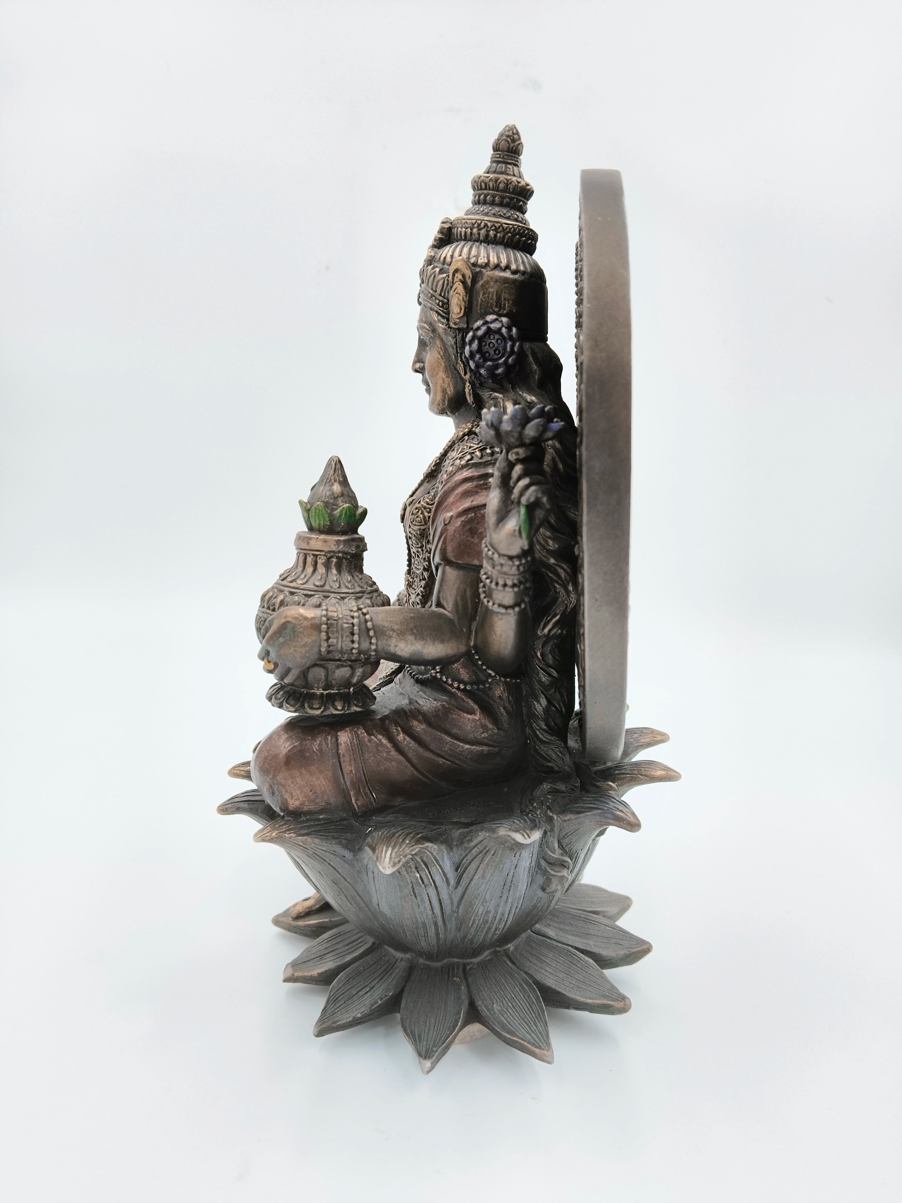 Side view of metallic fiber sculpture of Lakshmi seated on a lotus flower