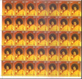 Full sheet of commemorative Sai Baba postage stamps with orange background