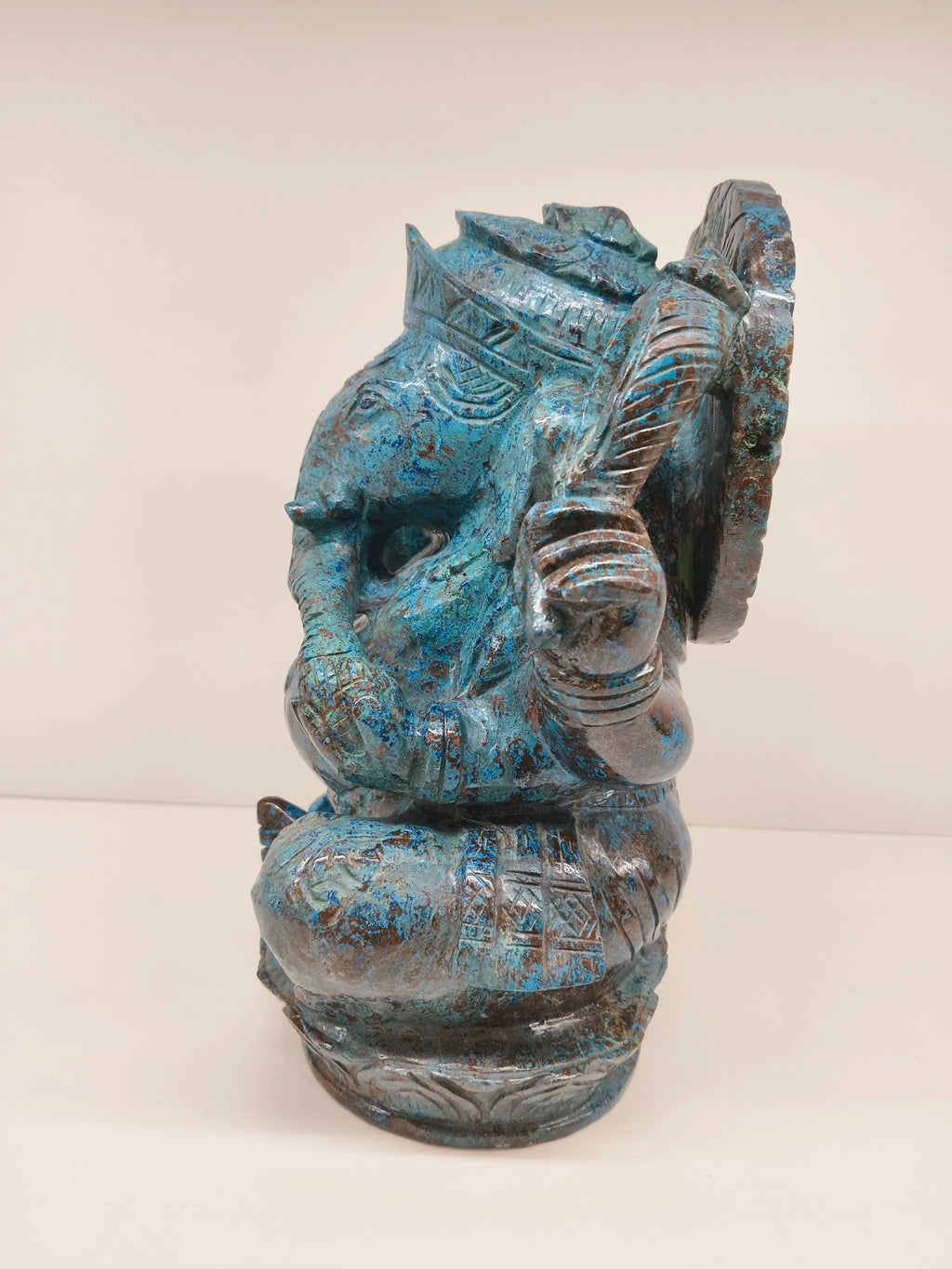 Side view of large Chrysocolla Ganesh sculpture with detailed carvings