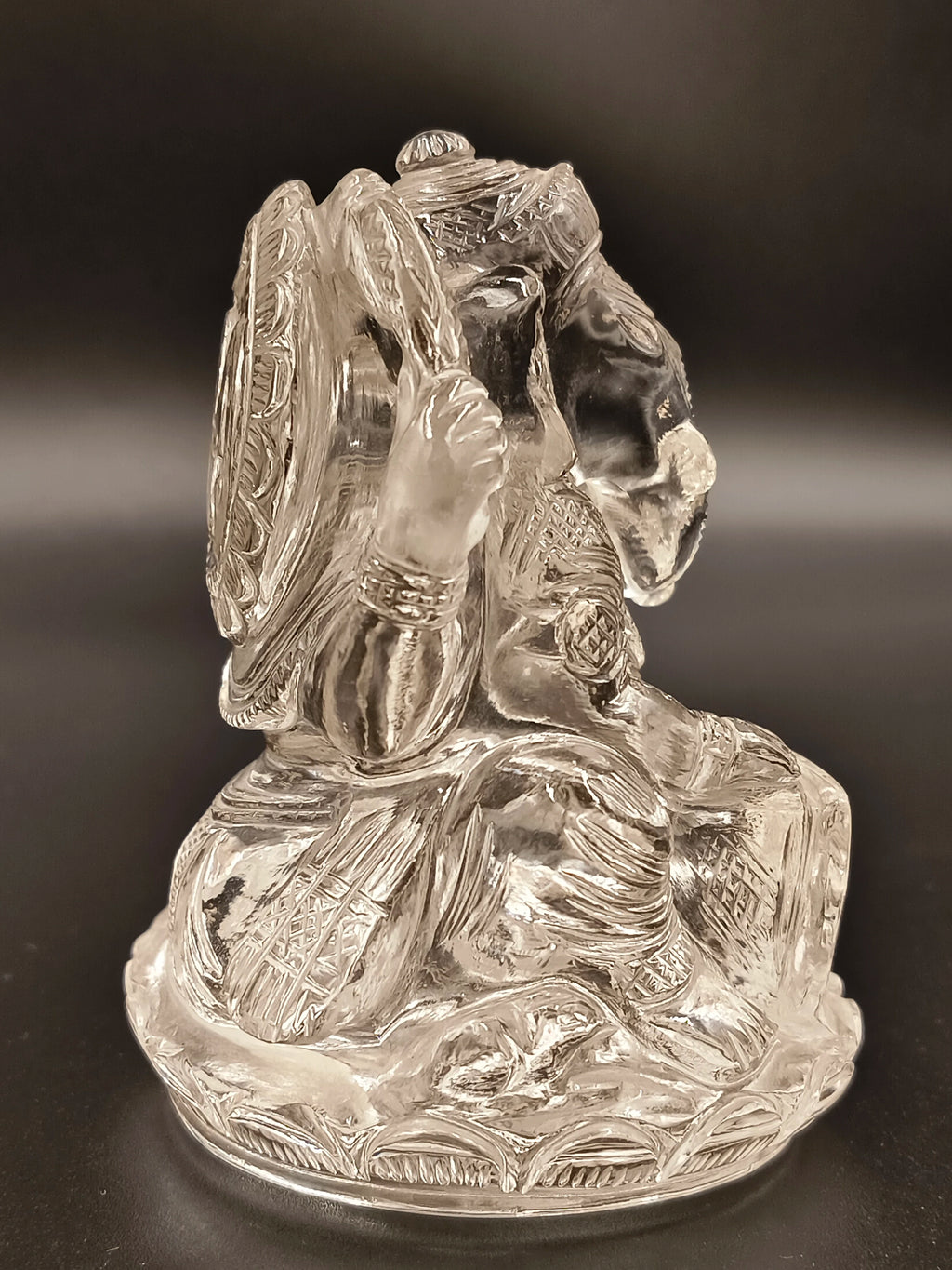 Crystal figurine of Hindu god Ganesh with intricate carvings, side view