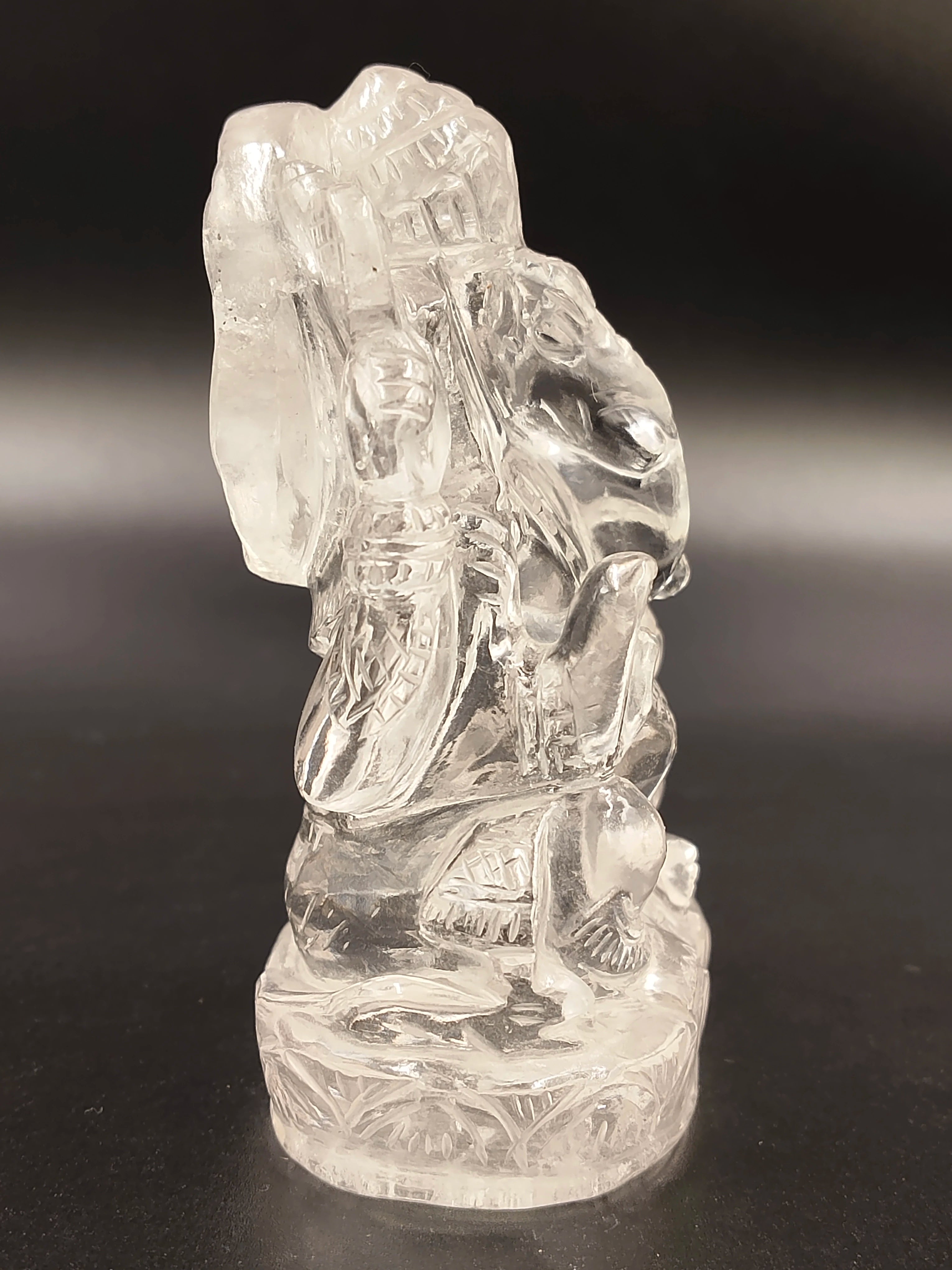 Small clear crystal Ganesha statue seated on decorated base