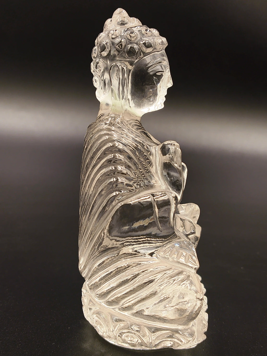 Side view of small 3.5-inch transparent crystal Buddha statue seated