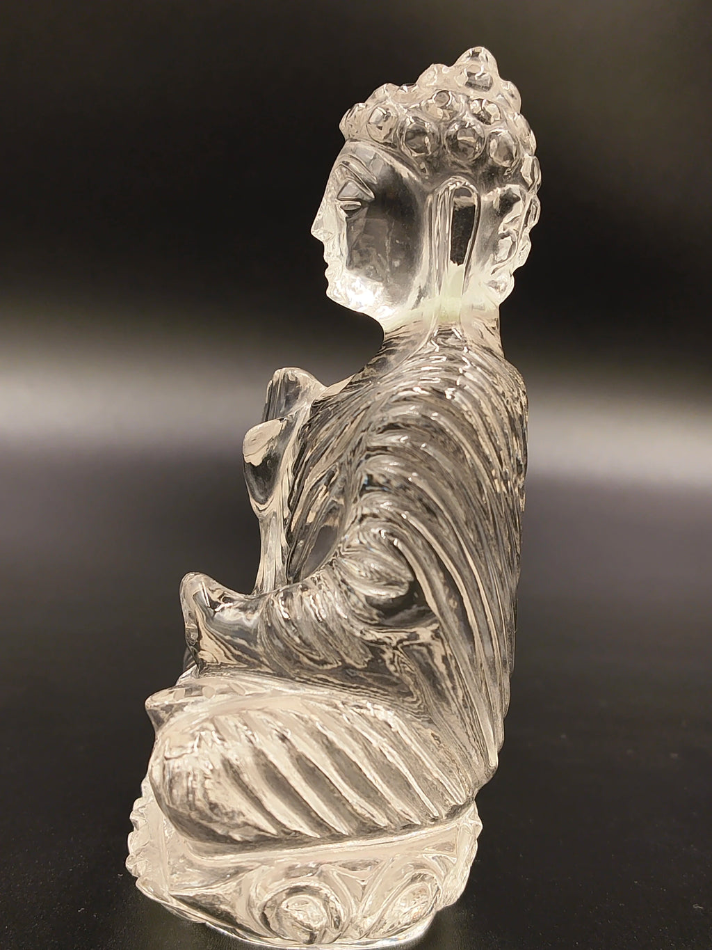 Side view of 3.5-inch clear crystal Buddha sculpture seated in meditation