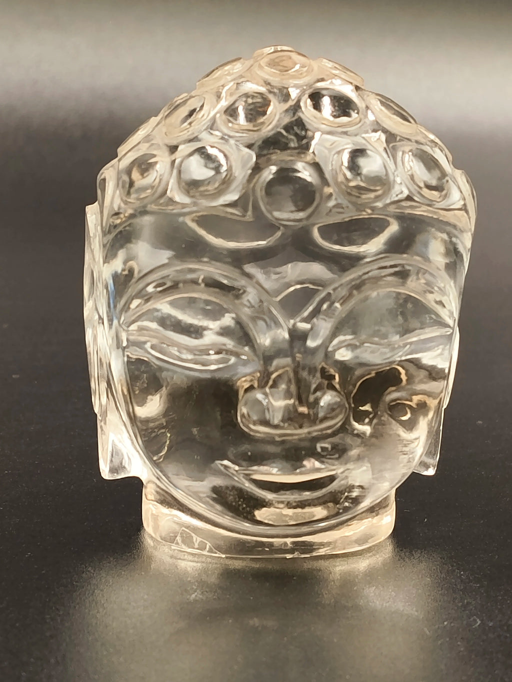 Clear crystal Buddha head sculpture with detailed facial features, front view