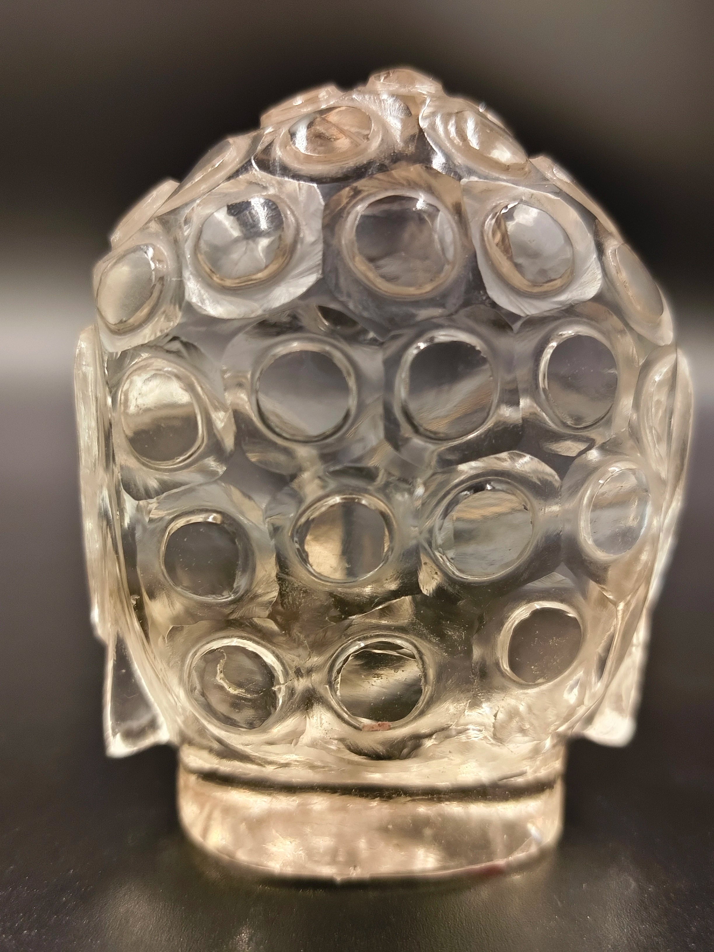Back view of clear crystal Buddha head sculpture with circular details