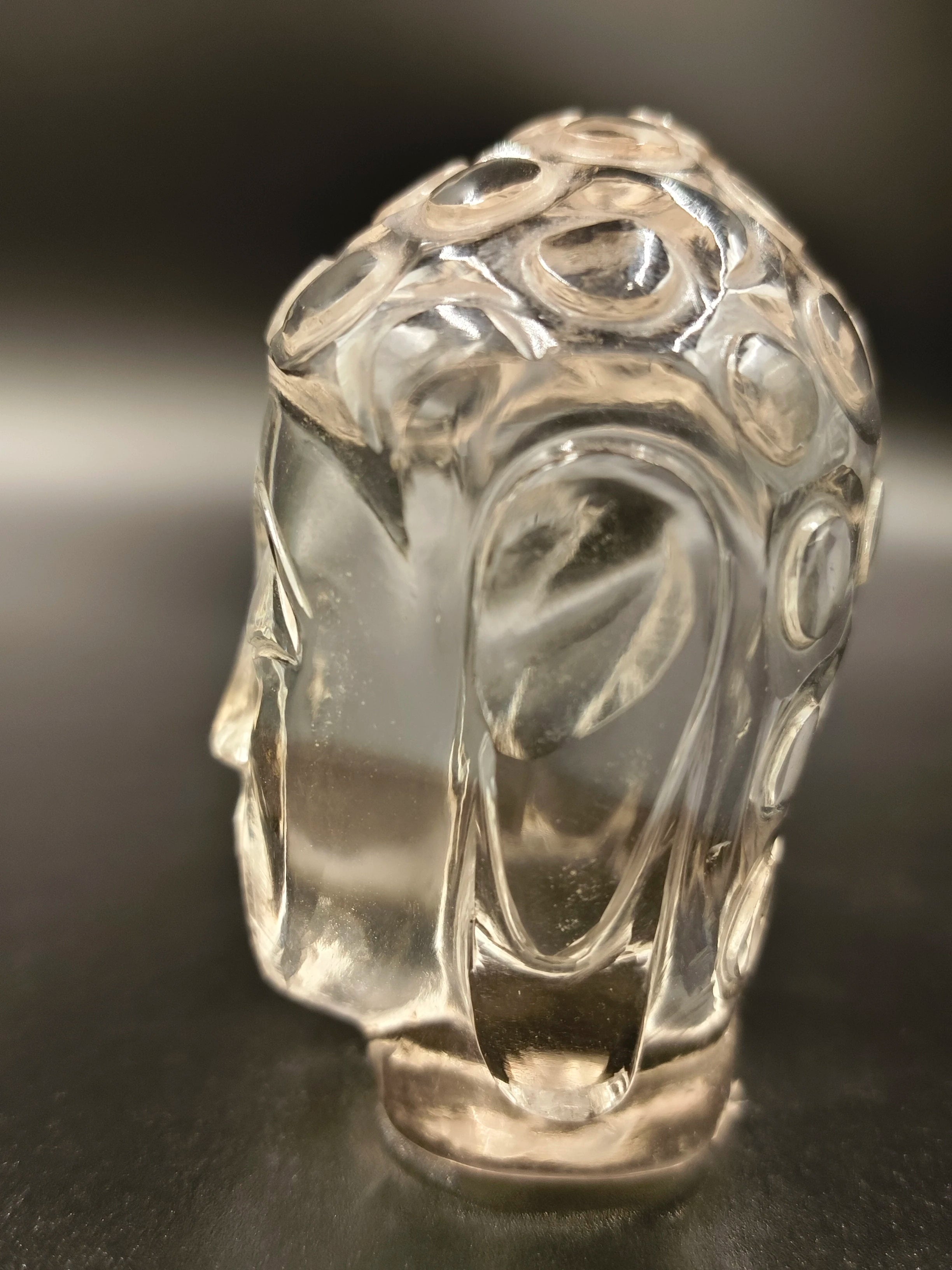 Clear crystal Buddha head sculpture with carved circular patterns
