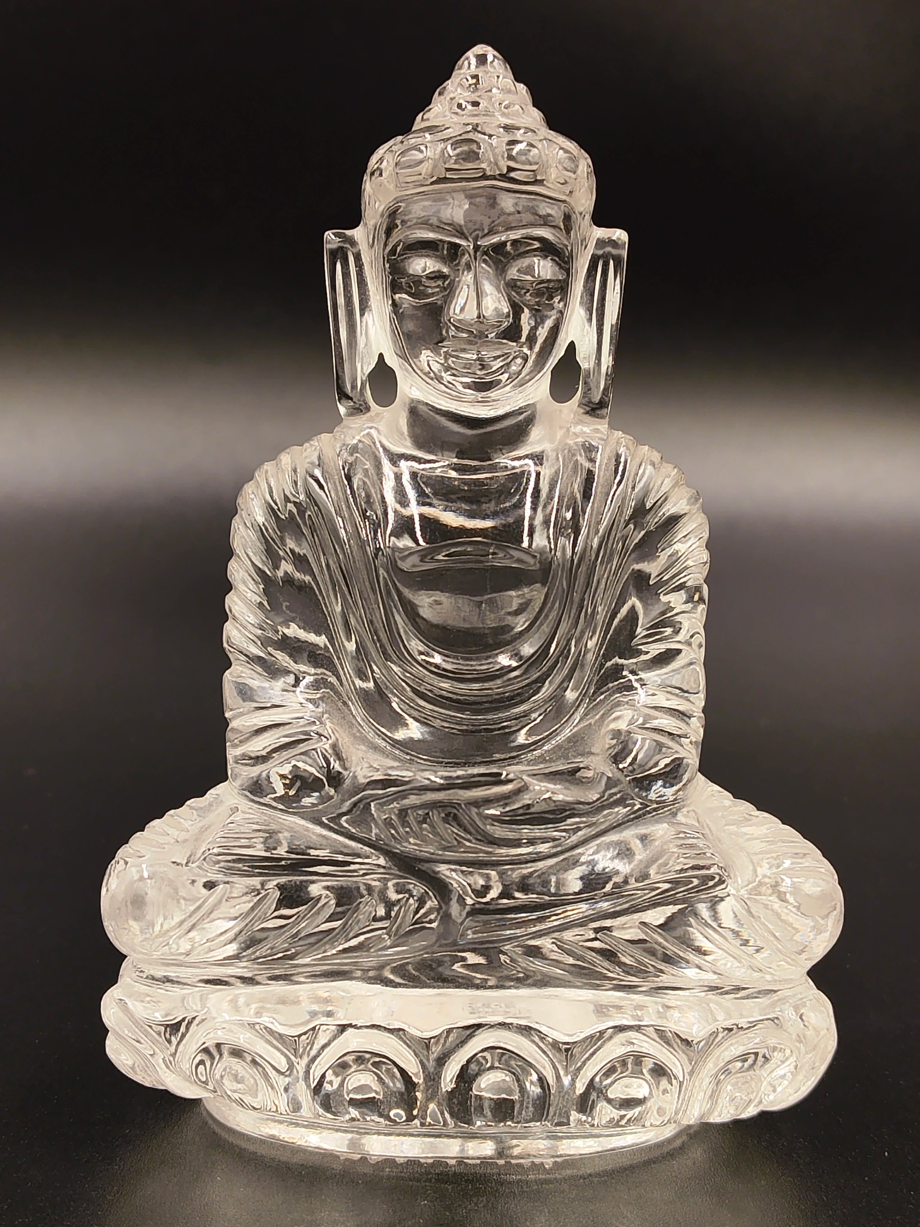 Clear crystal Buddha figurine seated in meditation, front view
