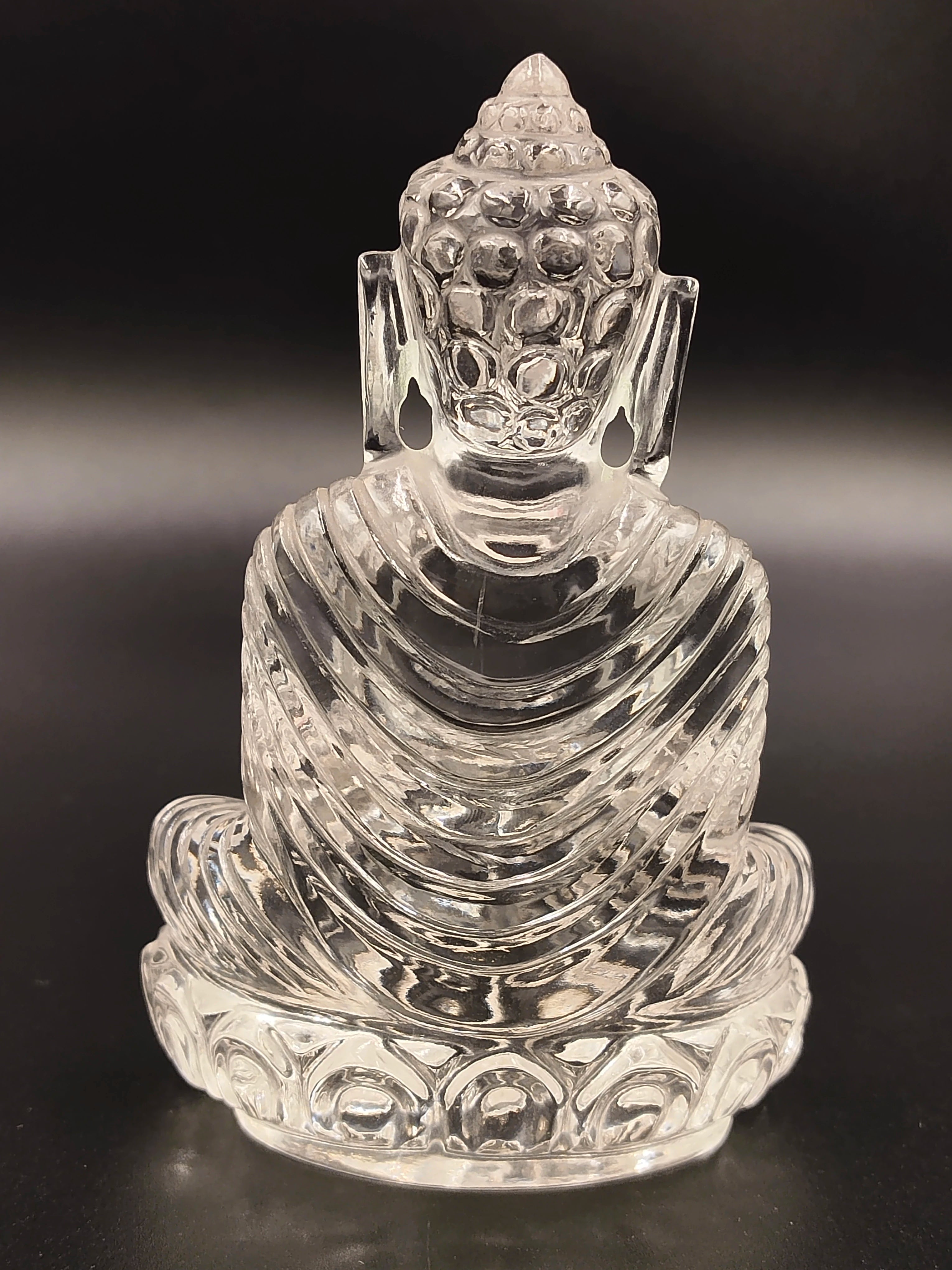 Clear crystal Buddha sculpture seated on lotus base, back view