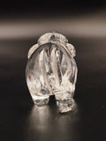 Back view of a clear crystal elephant figurine on dark surface