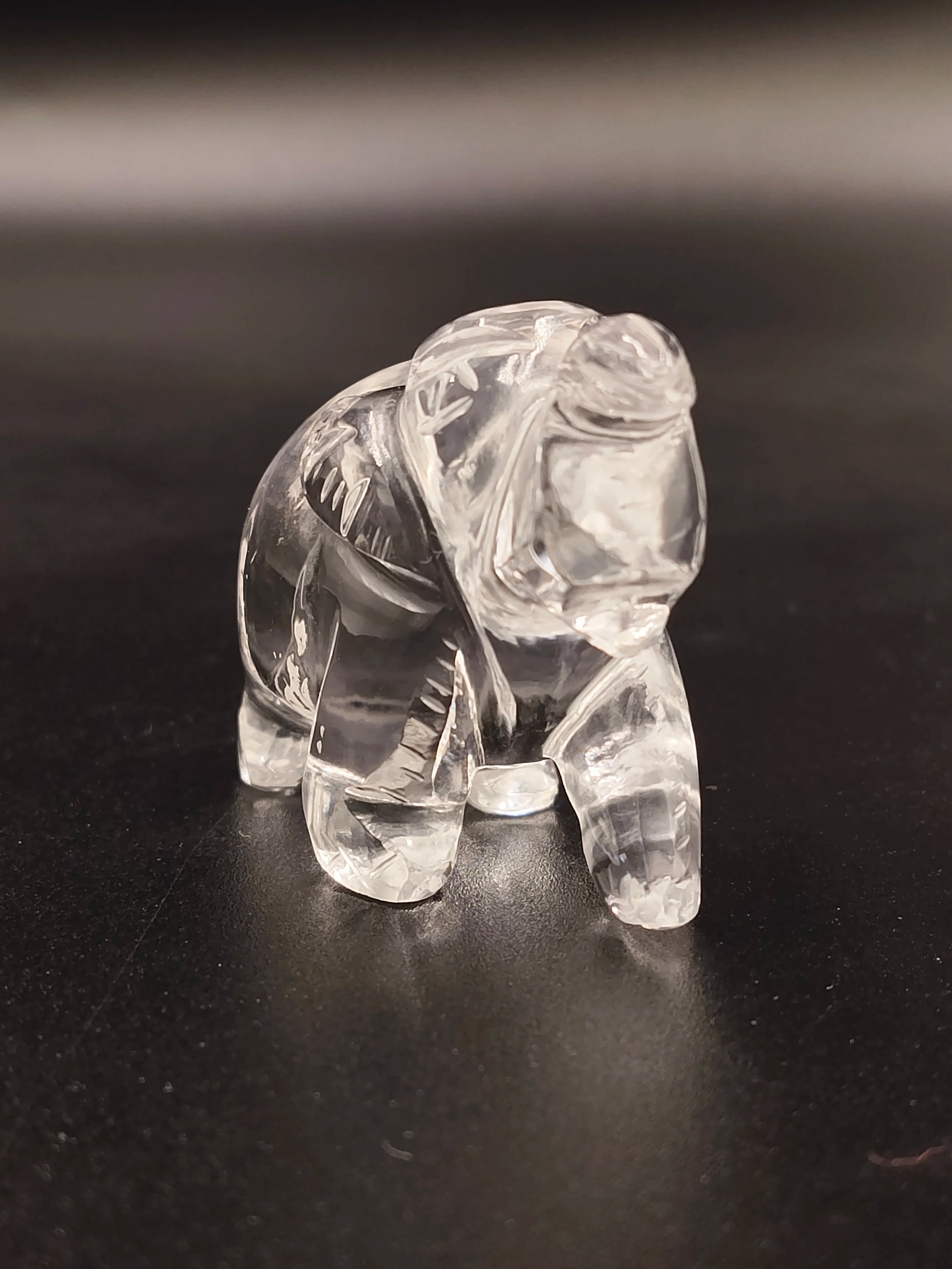 Small clear crystal elephant figurine on black surface
