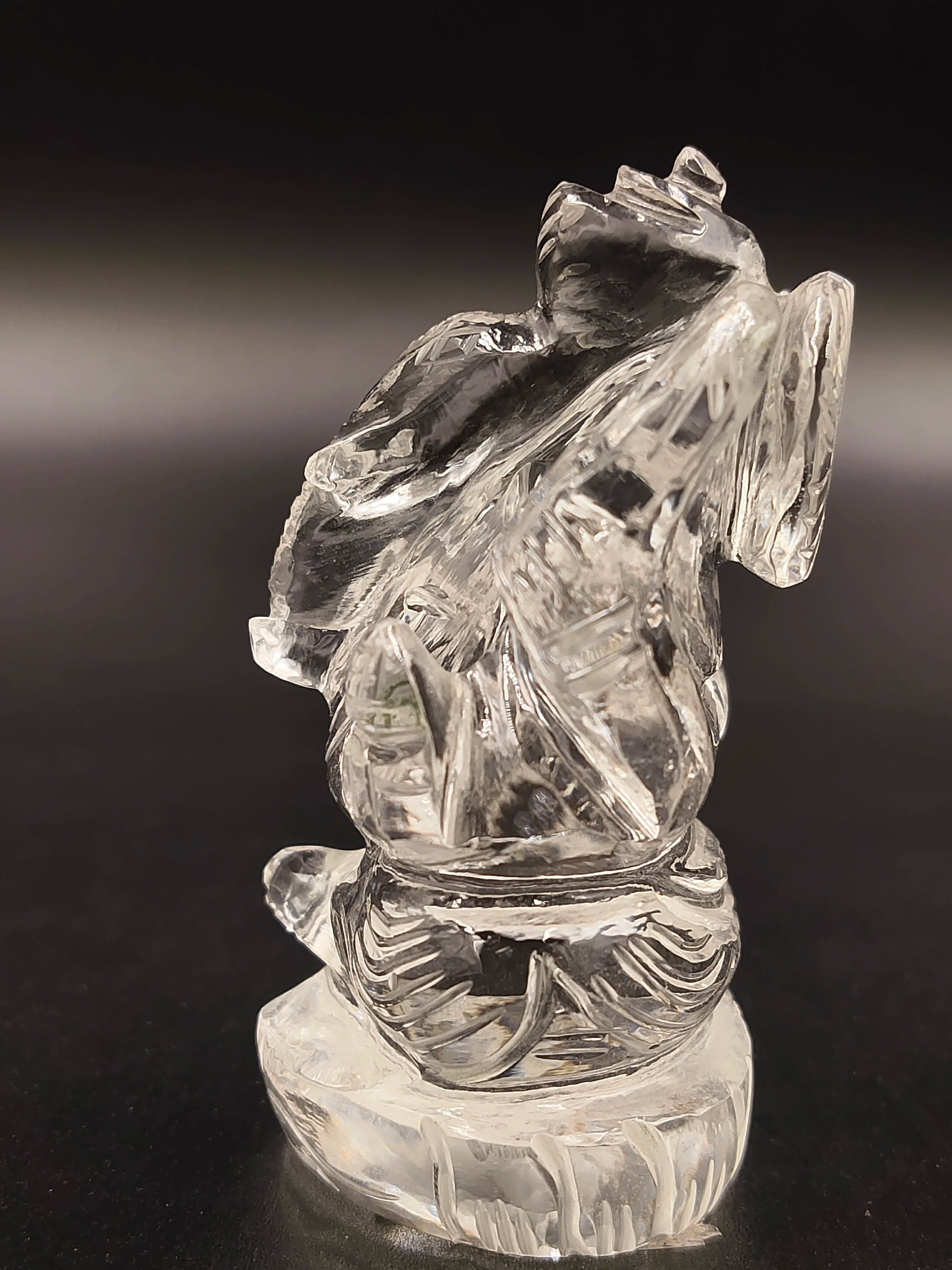 Clear crystal sculpture of Ganesh deity sitting on a round base