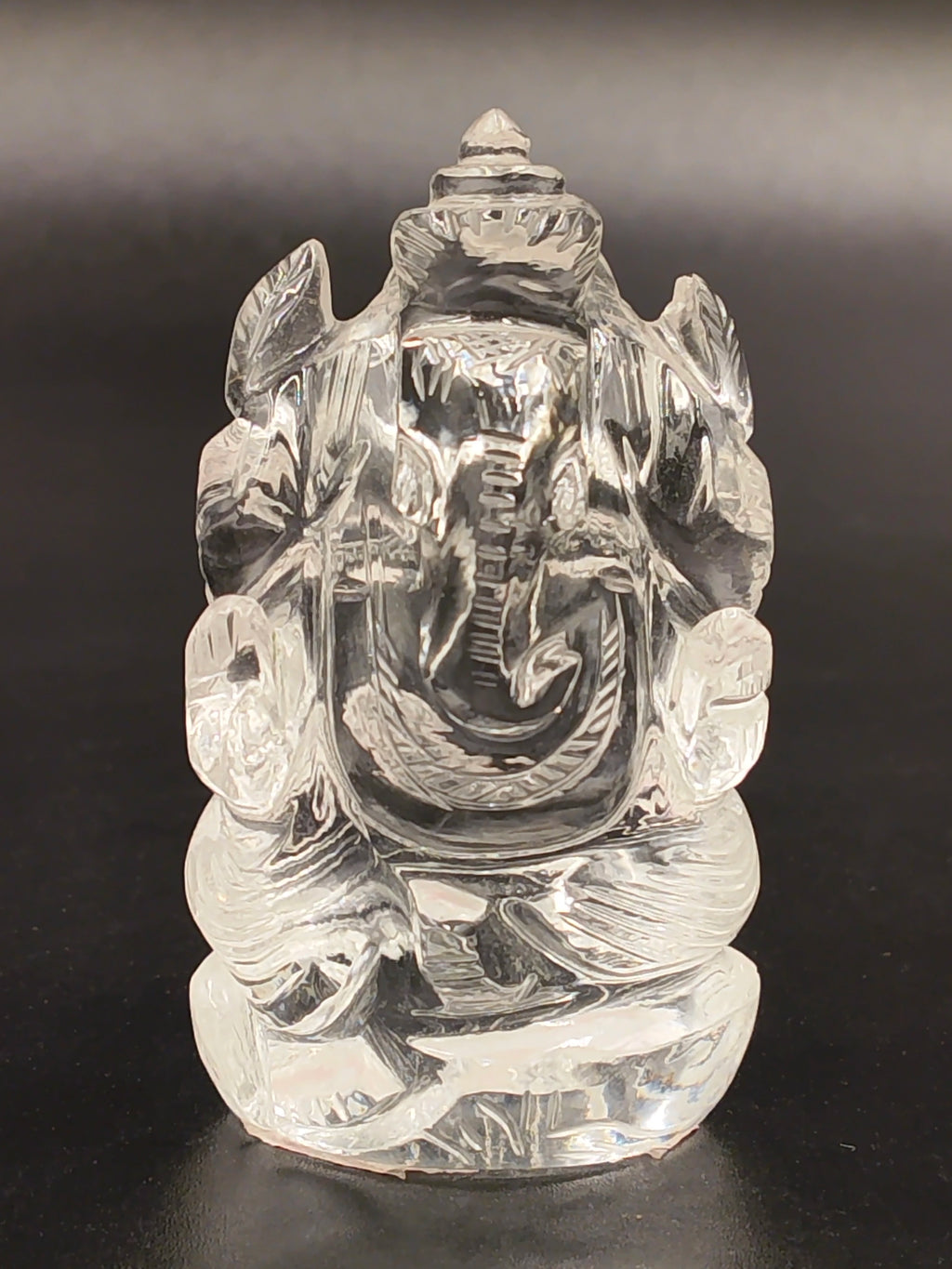 Clear crystal Ganesh statue with seated pose and detailed carving