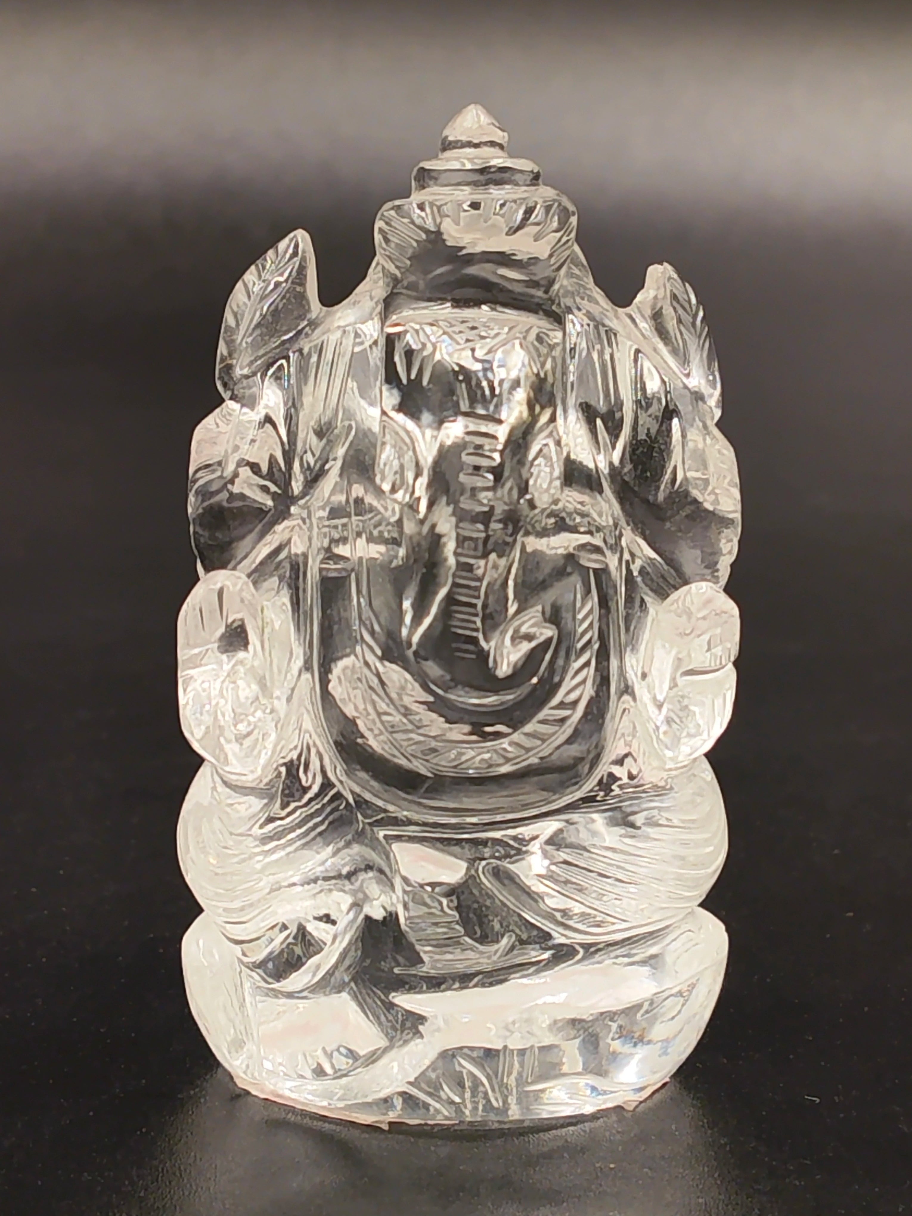 Clear crystal Ganesh statue with seated pose and detailed carving