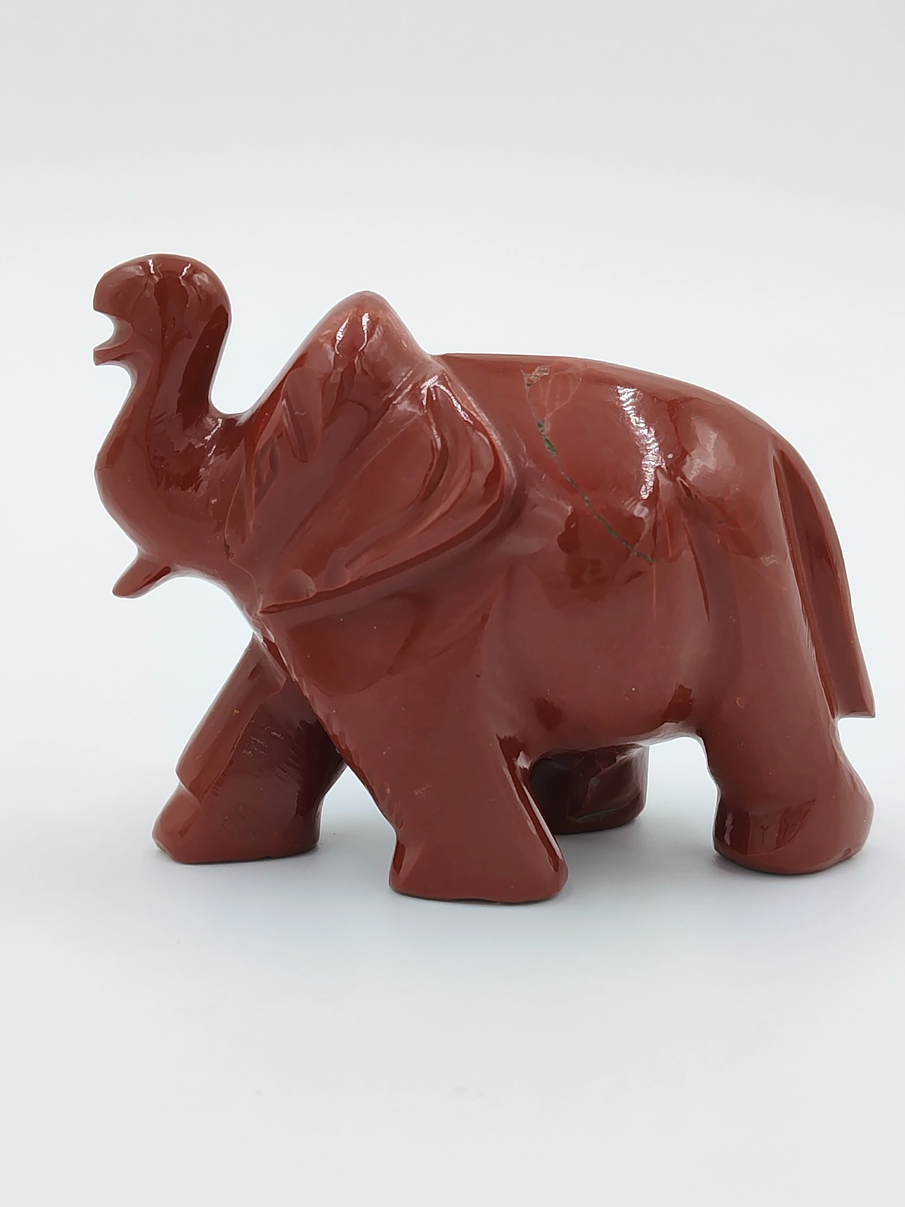 Red jasper elephant figurine sculpture with raised trunk side view