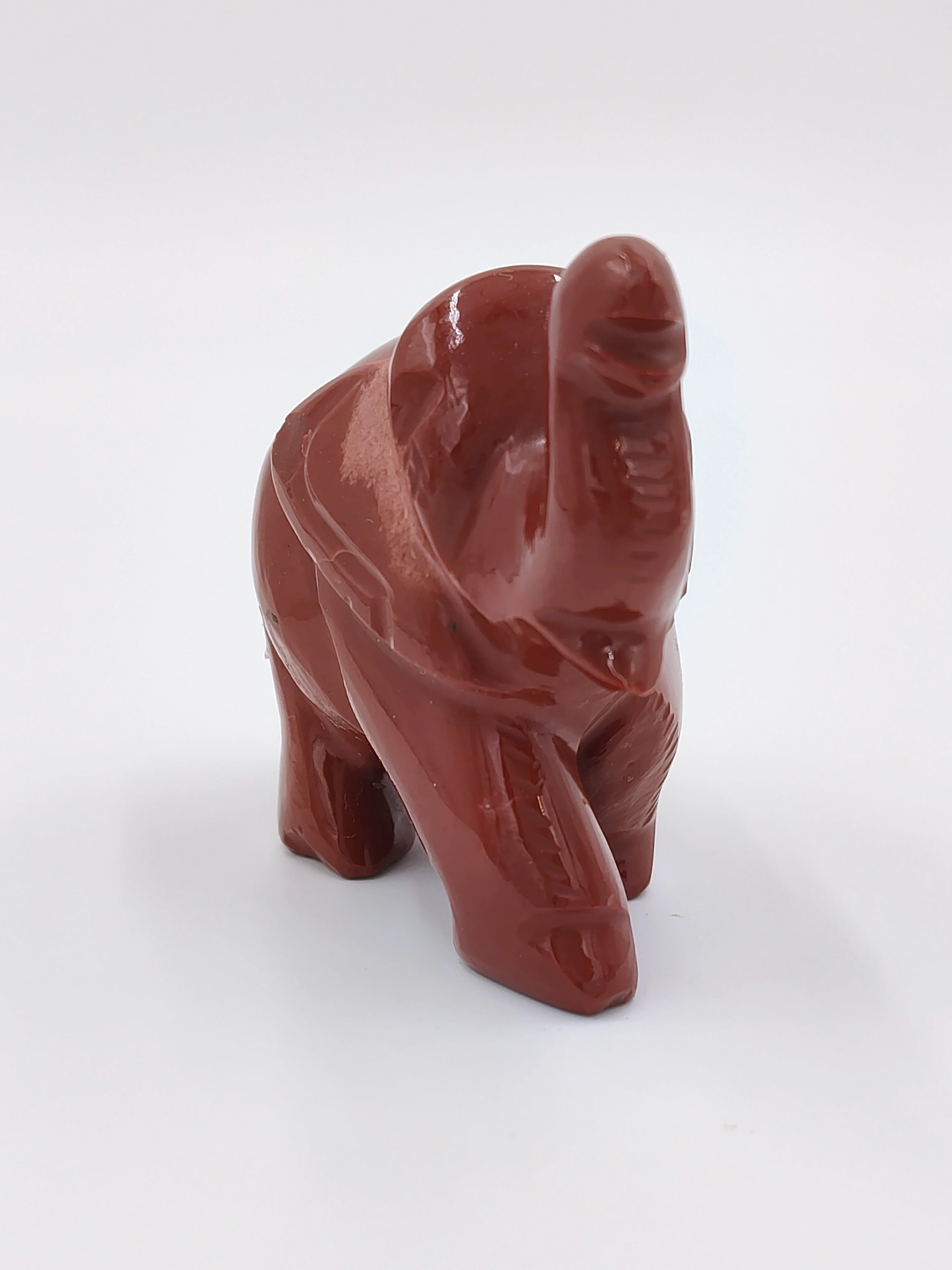 Miniature jasper elephant sculpture with raised trunk in side view