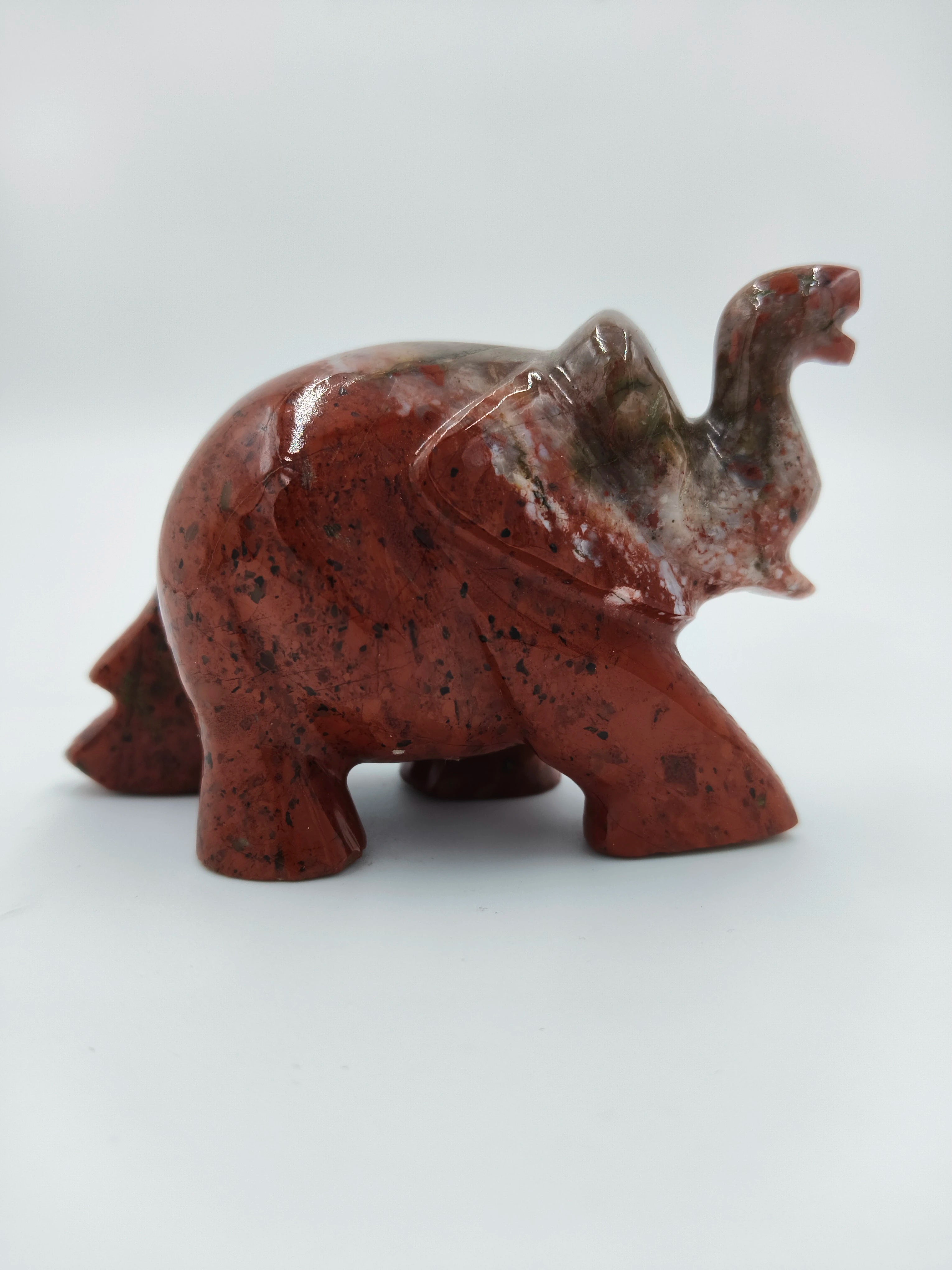 Polished jasper elephant figurine sculpture with marbled red and brown hues