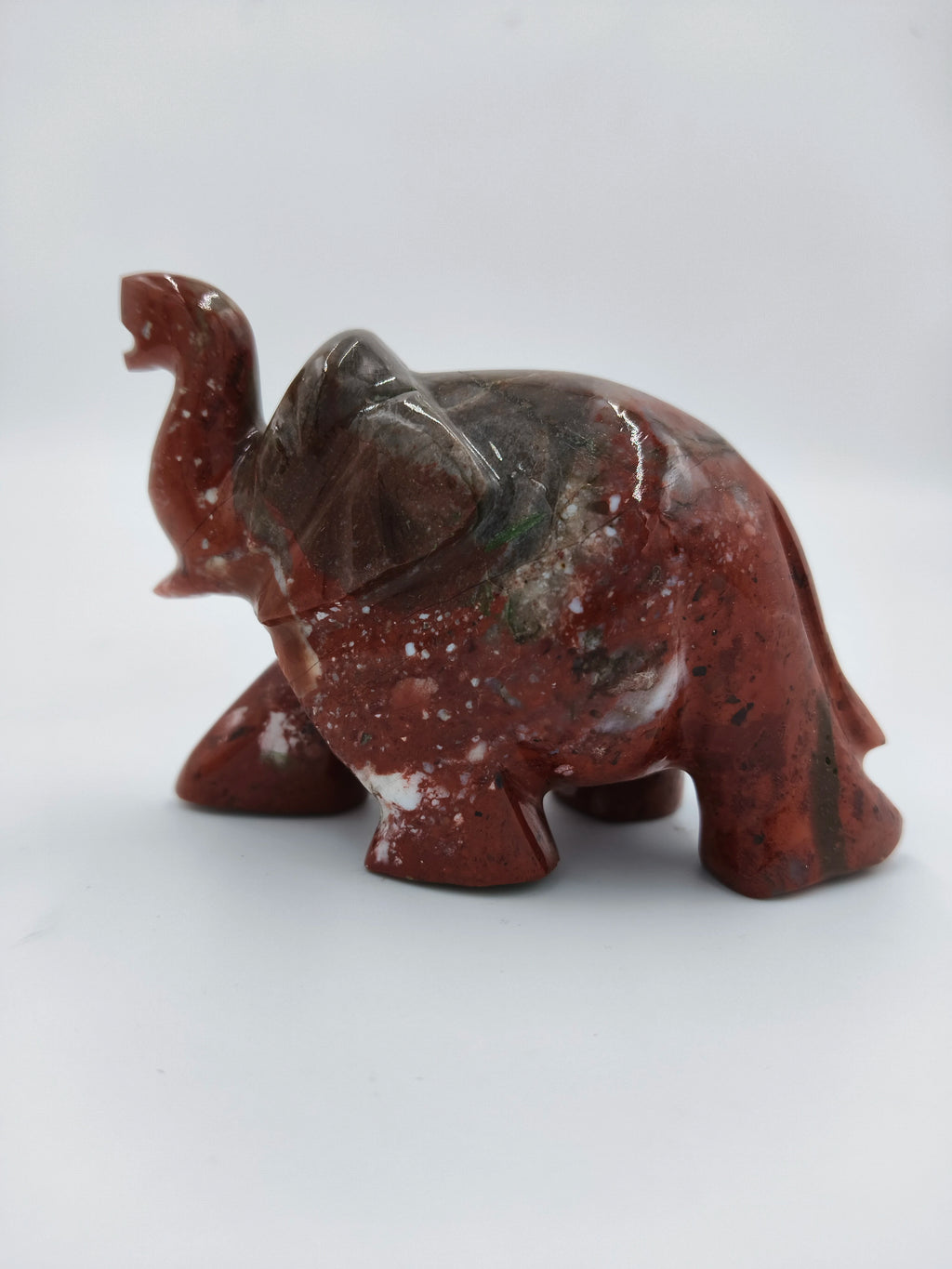 side view of a polished red jasper elephant figurine sculpture