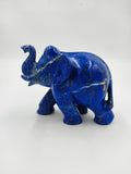 Small blue lapis elephant sculpture with raised trunk on white background