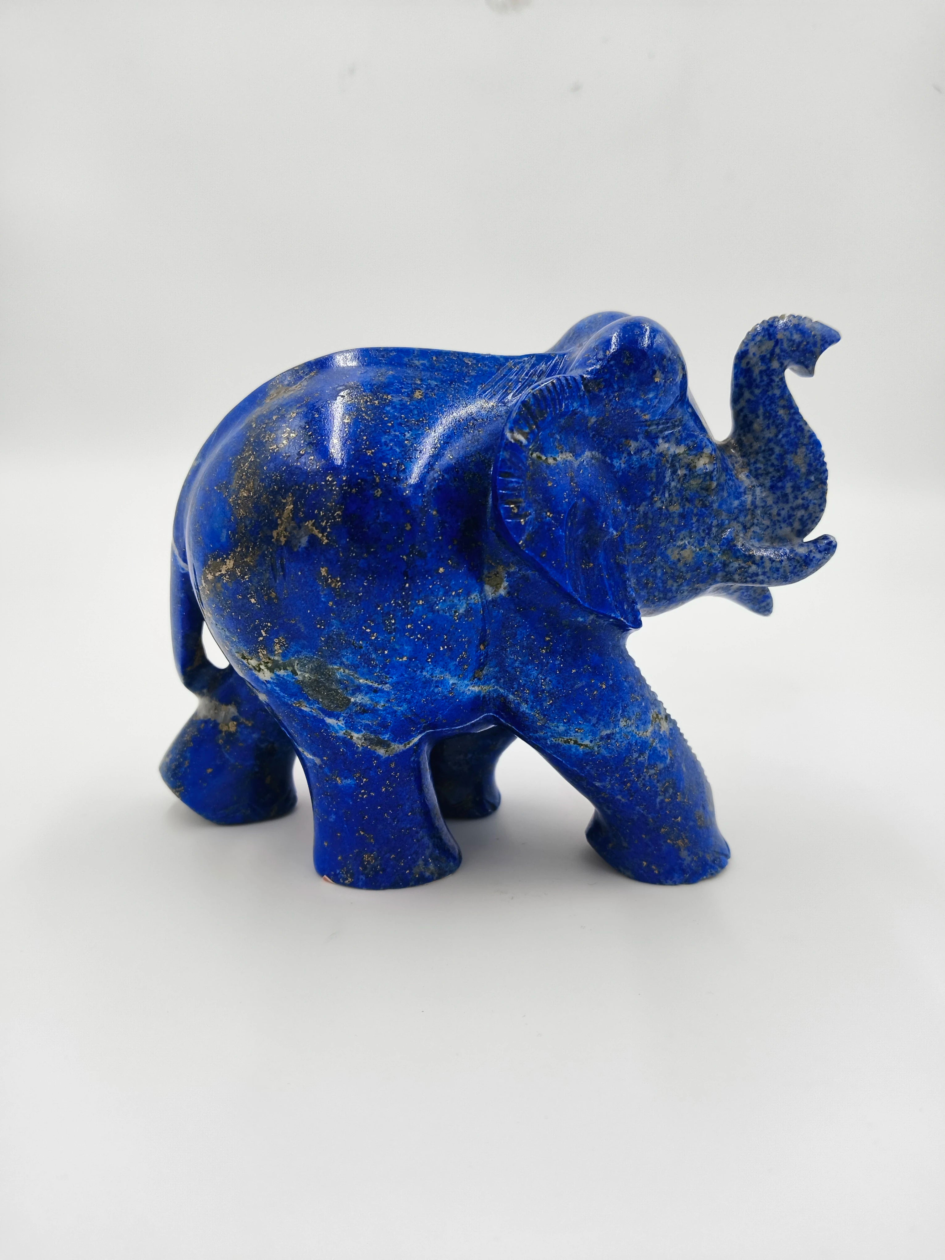 Blue lapis elephant sculpture with raised trunk, side view