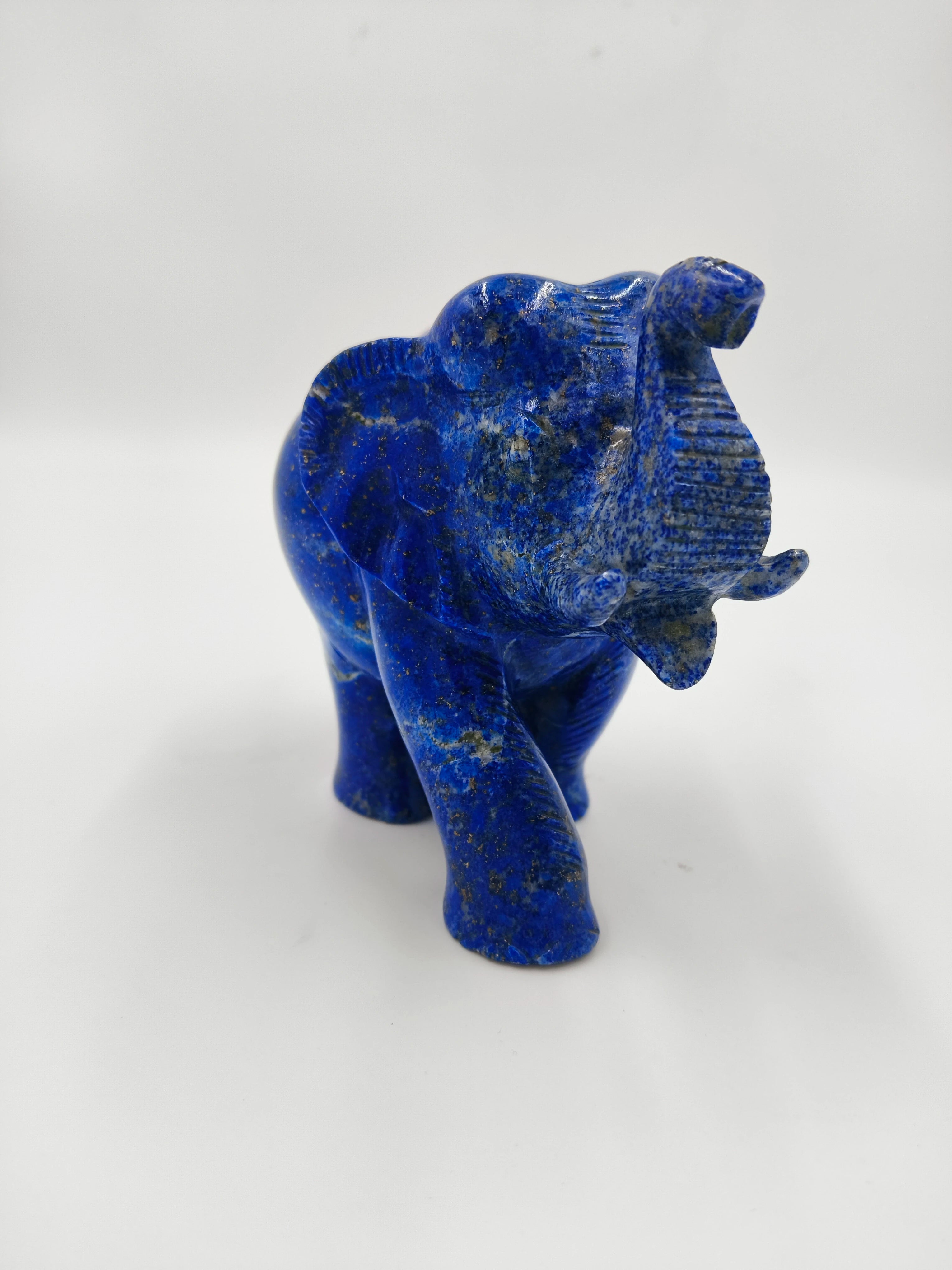 Small blue lapis elephant sculpture with raised trunk and detailed carving
