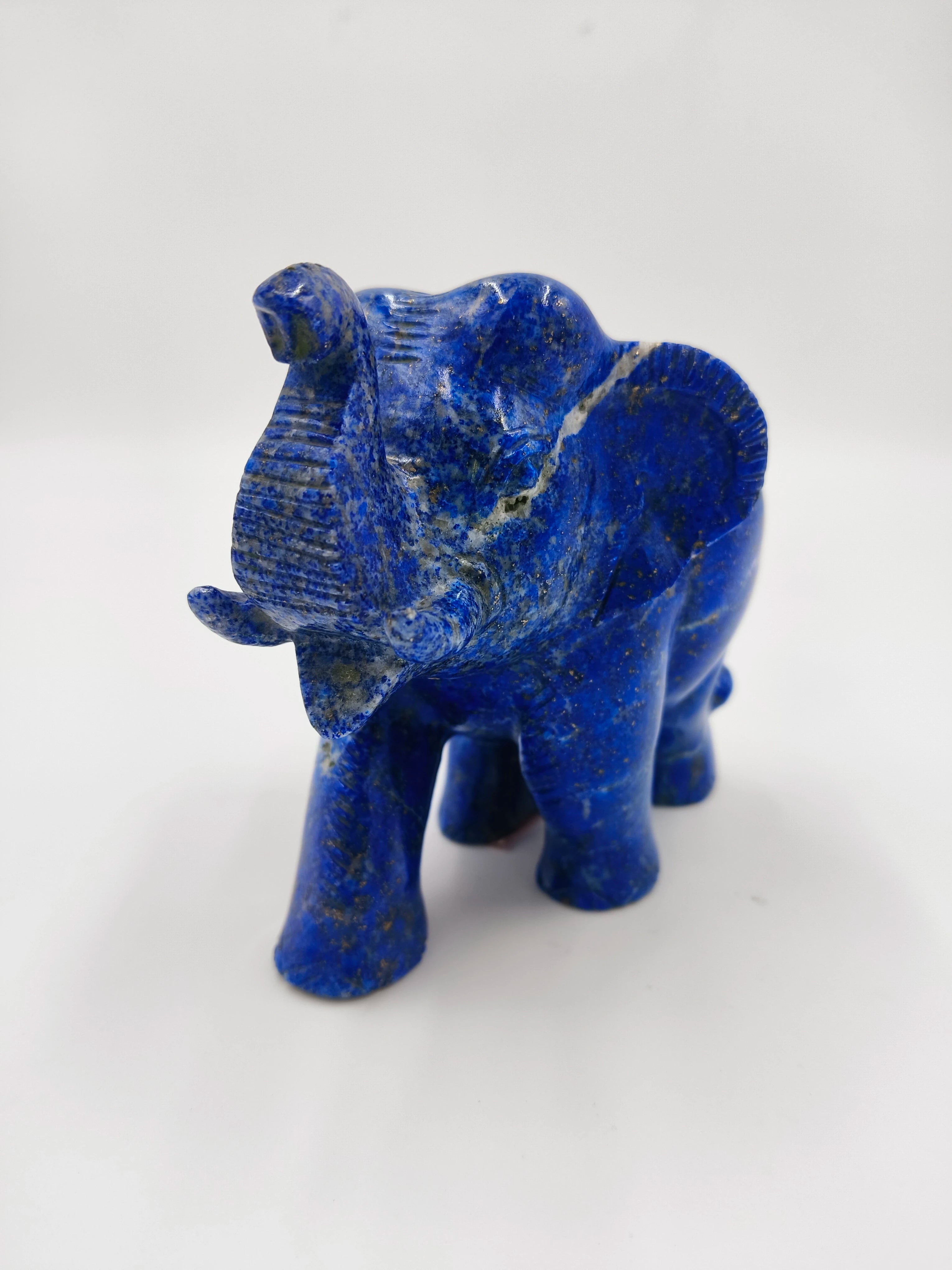 Small blue lapis elephant sculpture facing front on white background