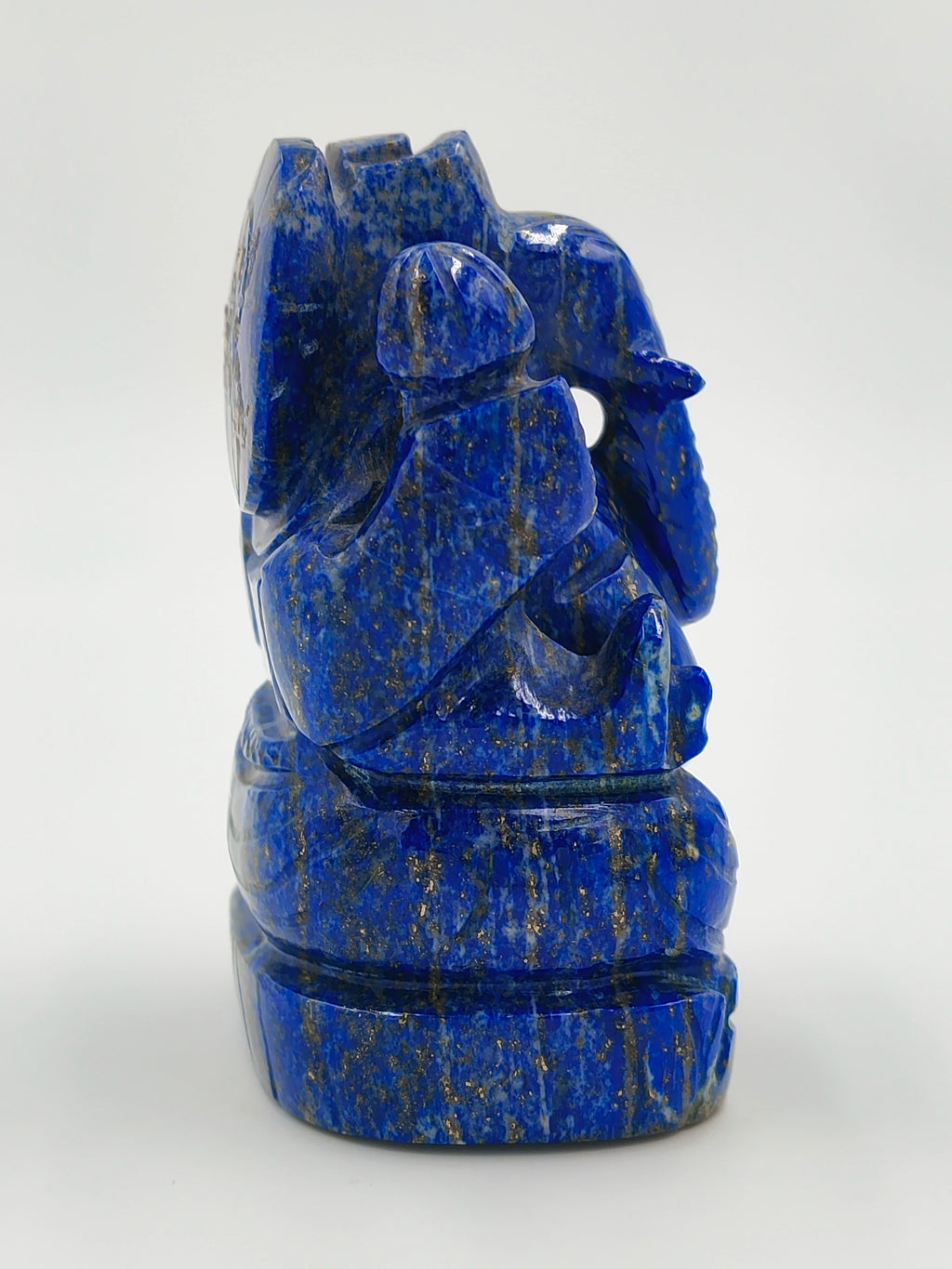 Side view of blue lapis stone Ganesh sculpture seated on a base
