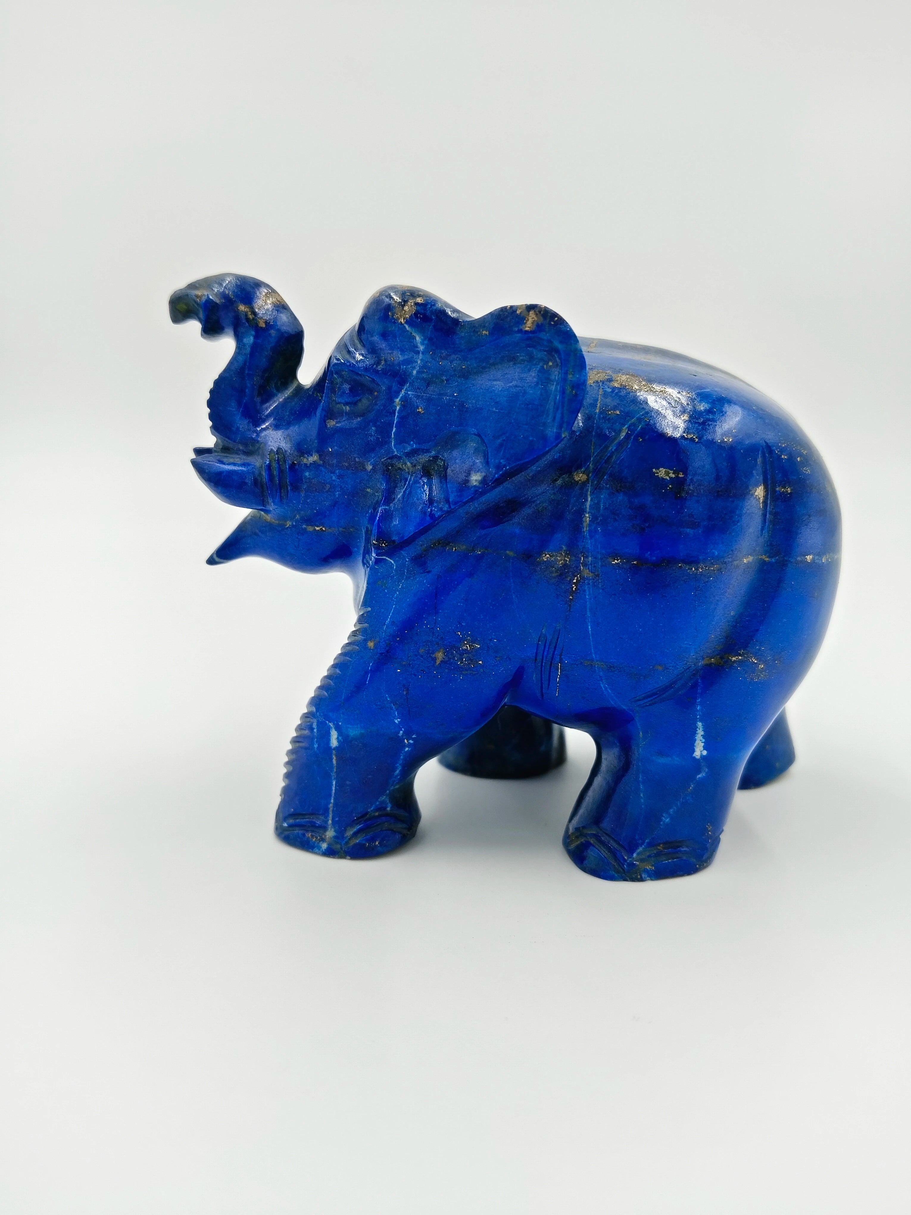 Small lapis lazuli elephant sculpture with raised trunk and gold flecks
