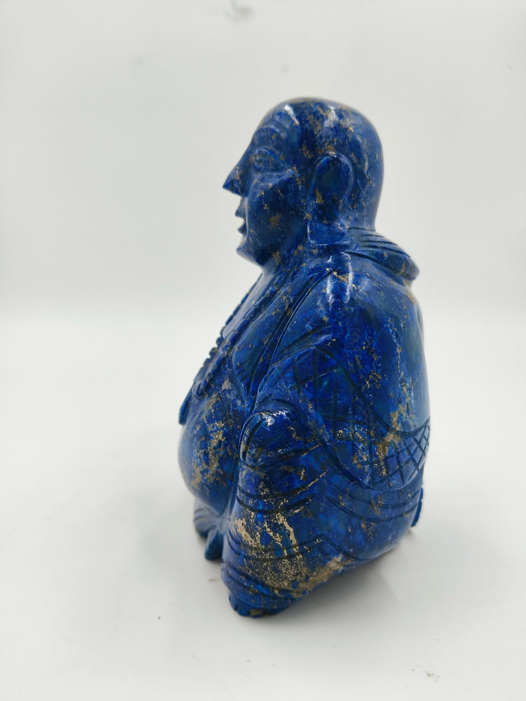 Side view of a blue lapis laughing Buddha figurine sculpture