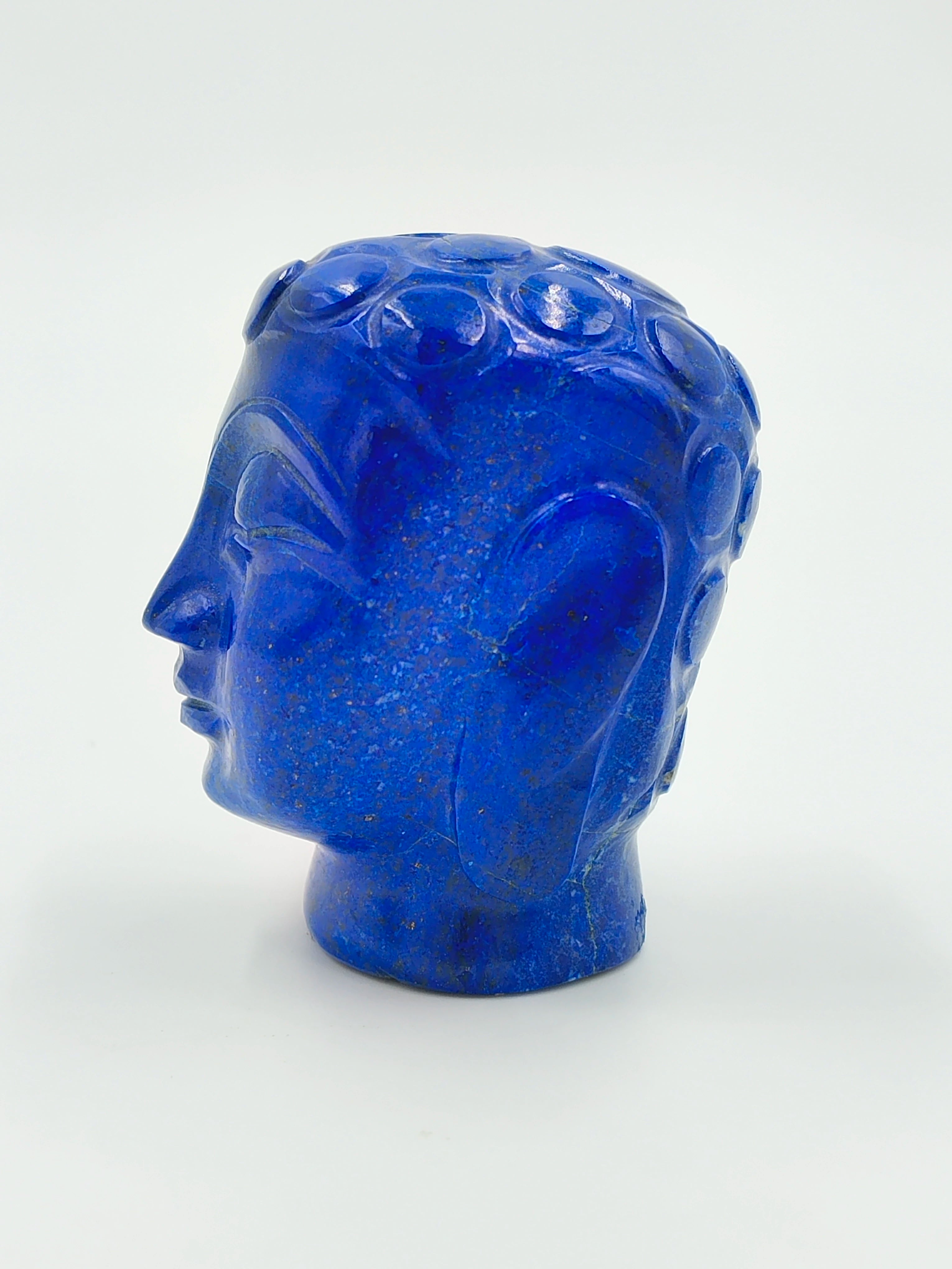 Side view of a small blue lapis lazuli Buddha head sculpture