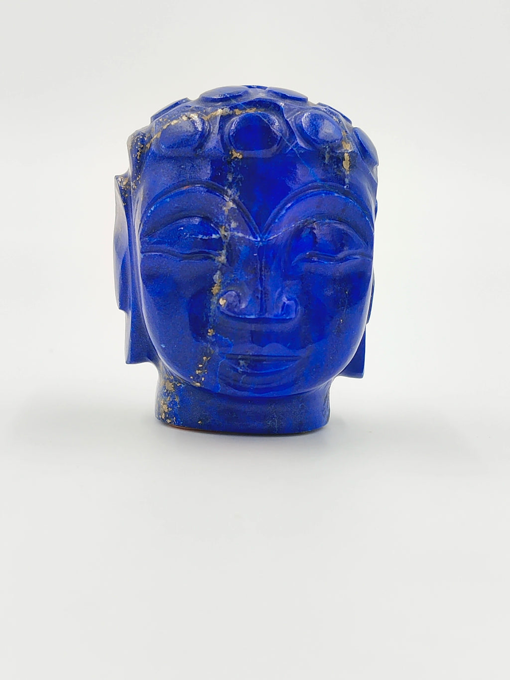 Miniature Buddha head sculpture carved from blue lapis stone, front view