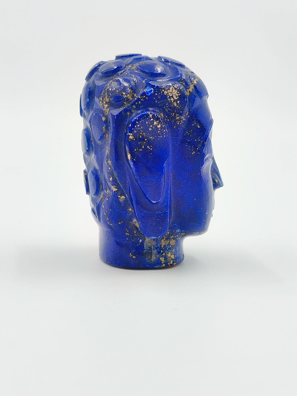 Side view of a small lapis lazuli Buddha head sculpture