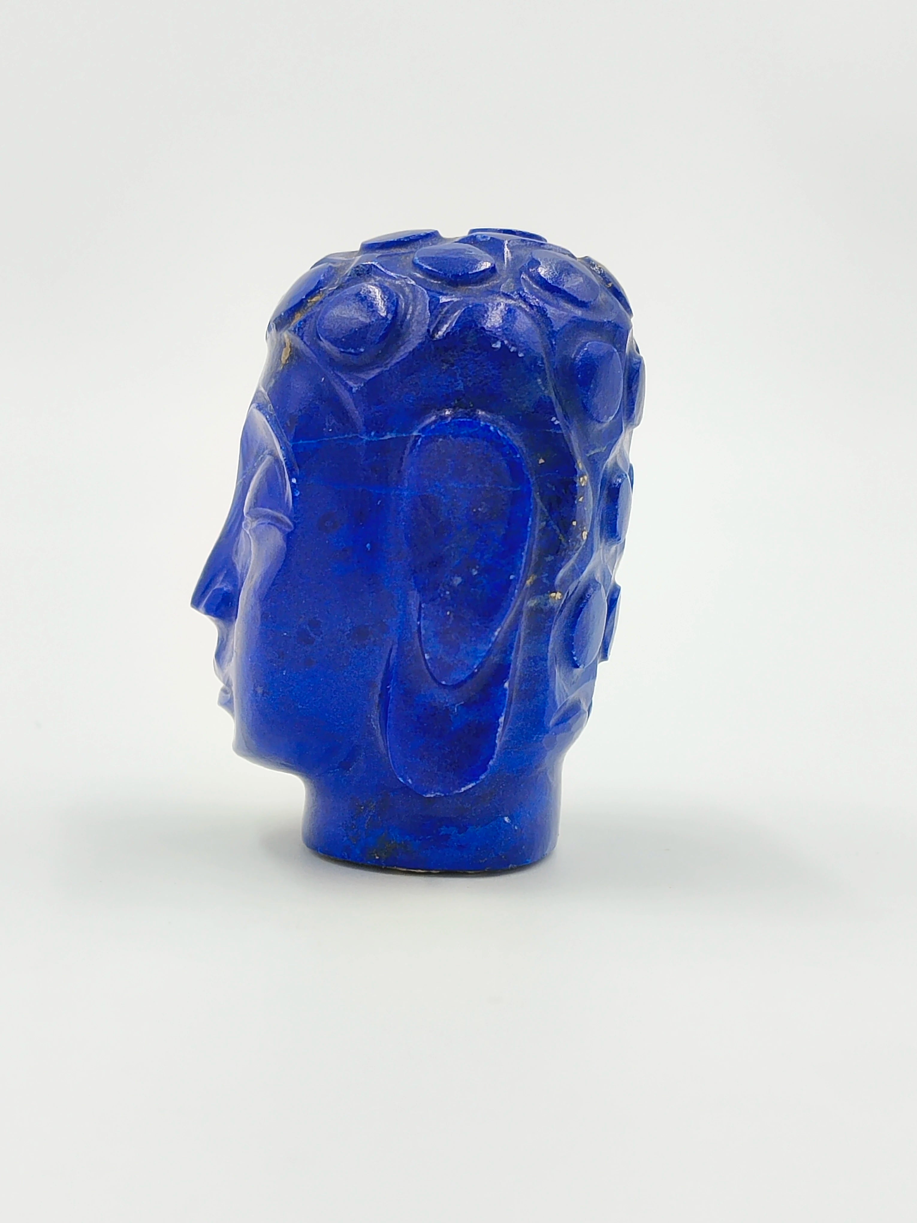 Side view of a small lapis lazuli Buddha head sculpture