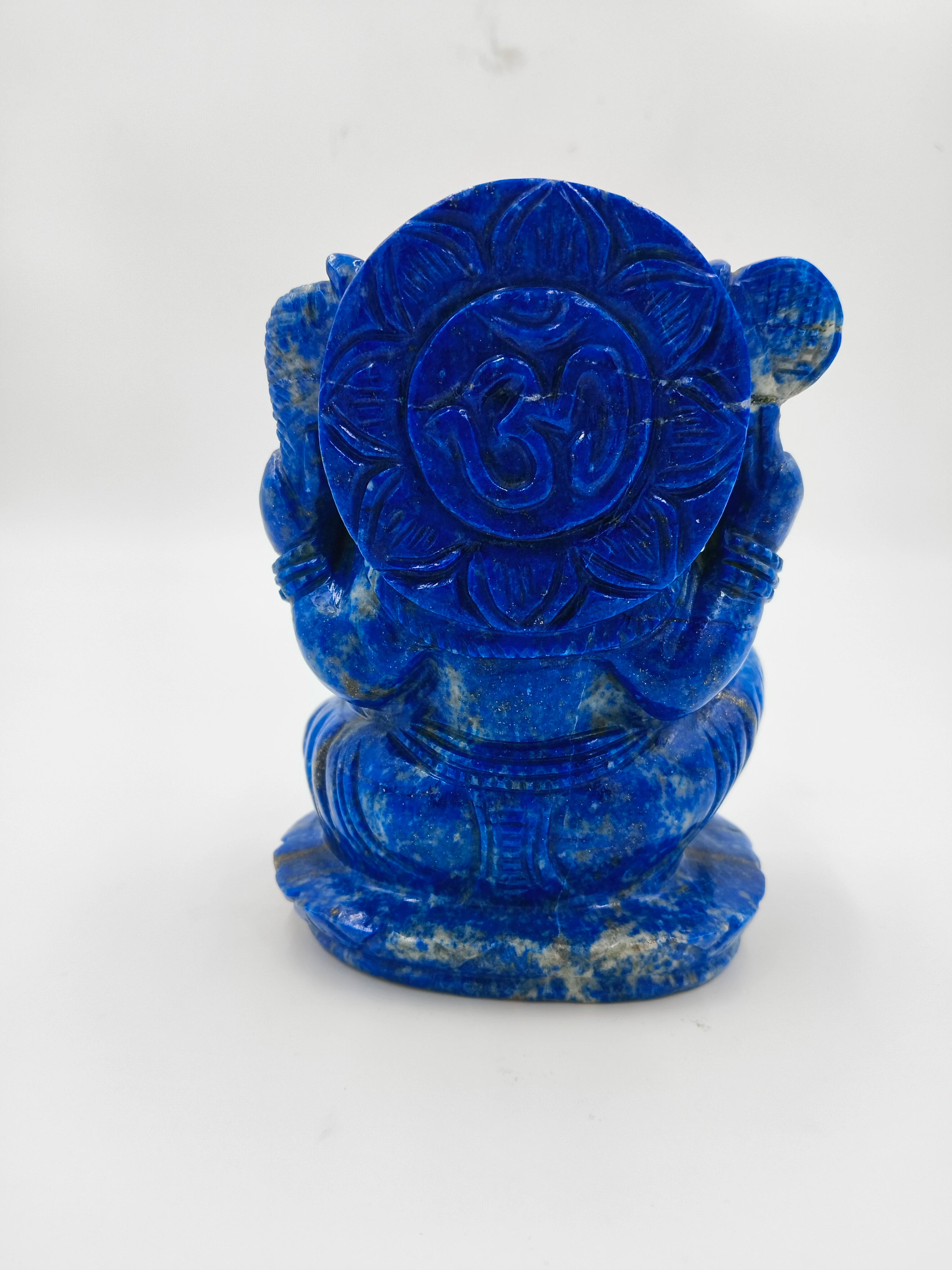 Back view of a carved lapis blue Ganesh statue holding a lotus base
