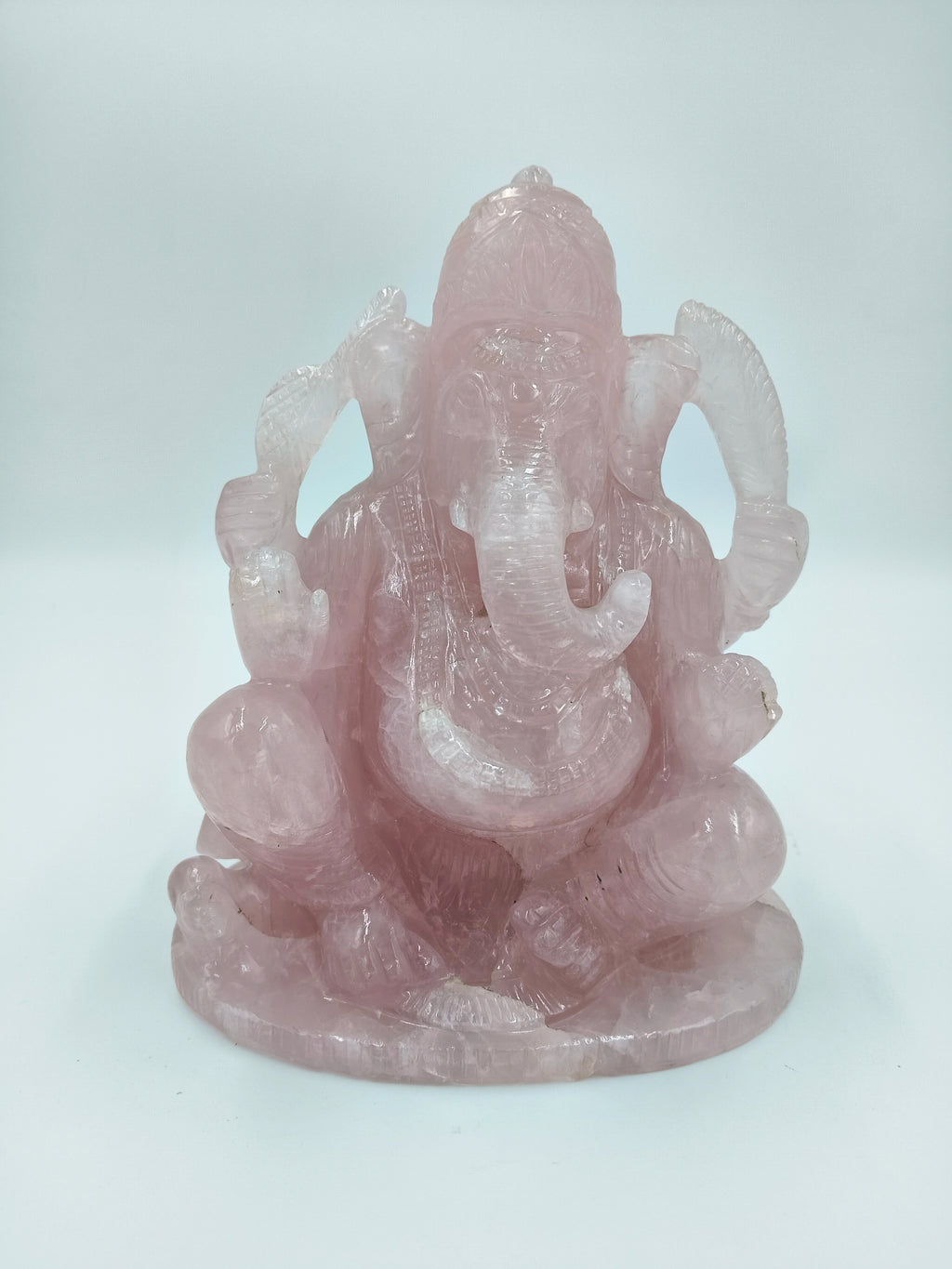 Large rose quartz sculpture of the Hindu deity Ganesh sitting cross-legged
