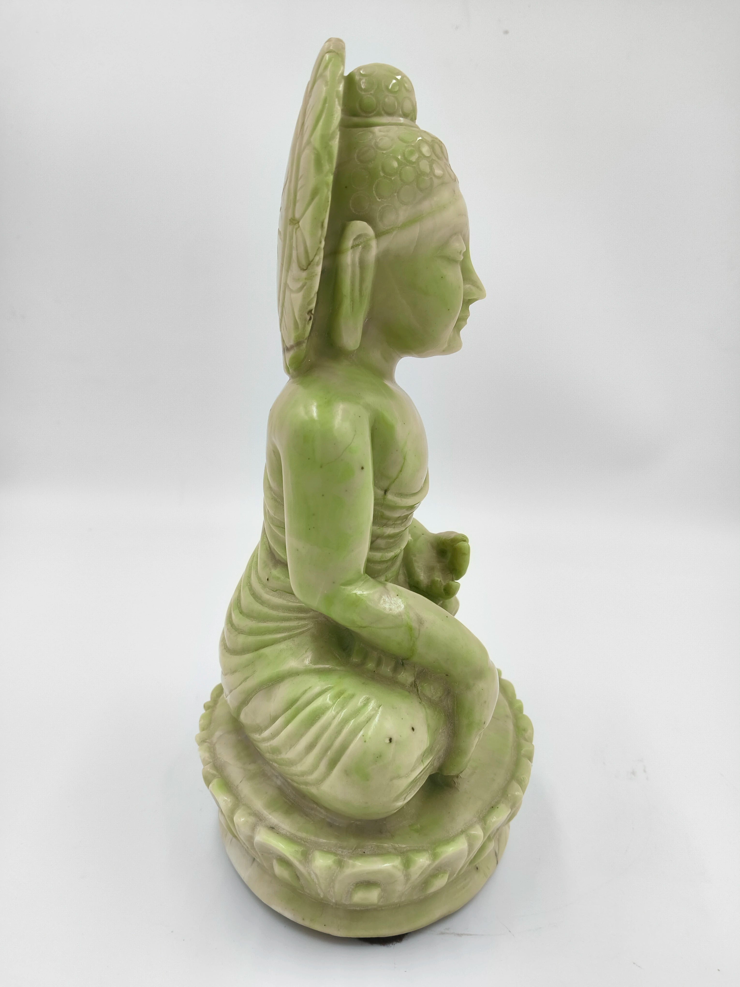 Side view of green serpentine stone Buddha sculpture seated on lotus pedestal