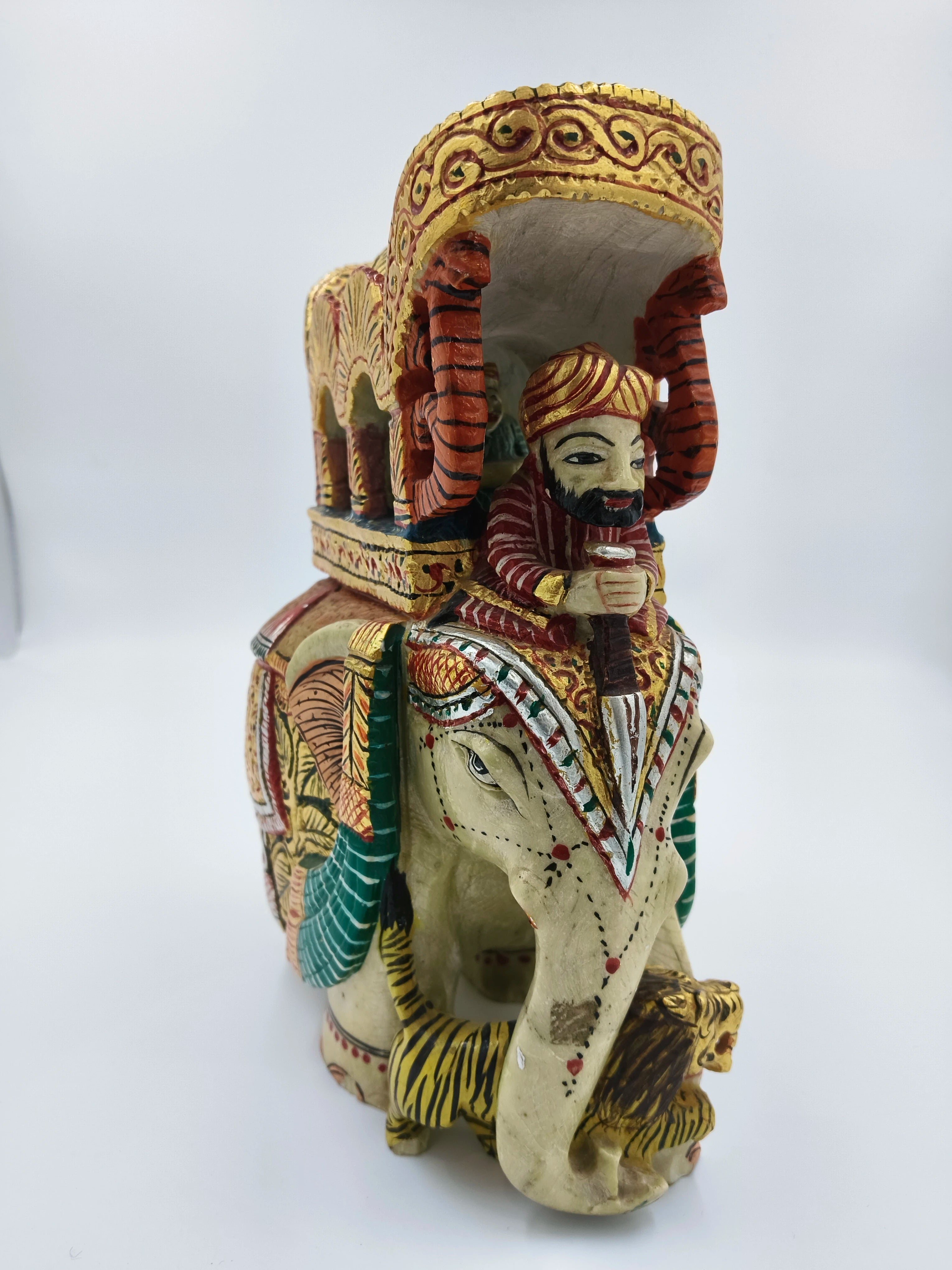 Serpentine elephant ambari sculpture with painted rider and decorative canopy