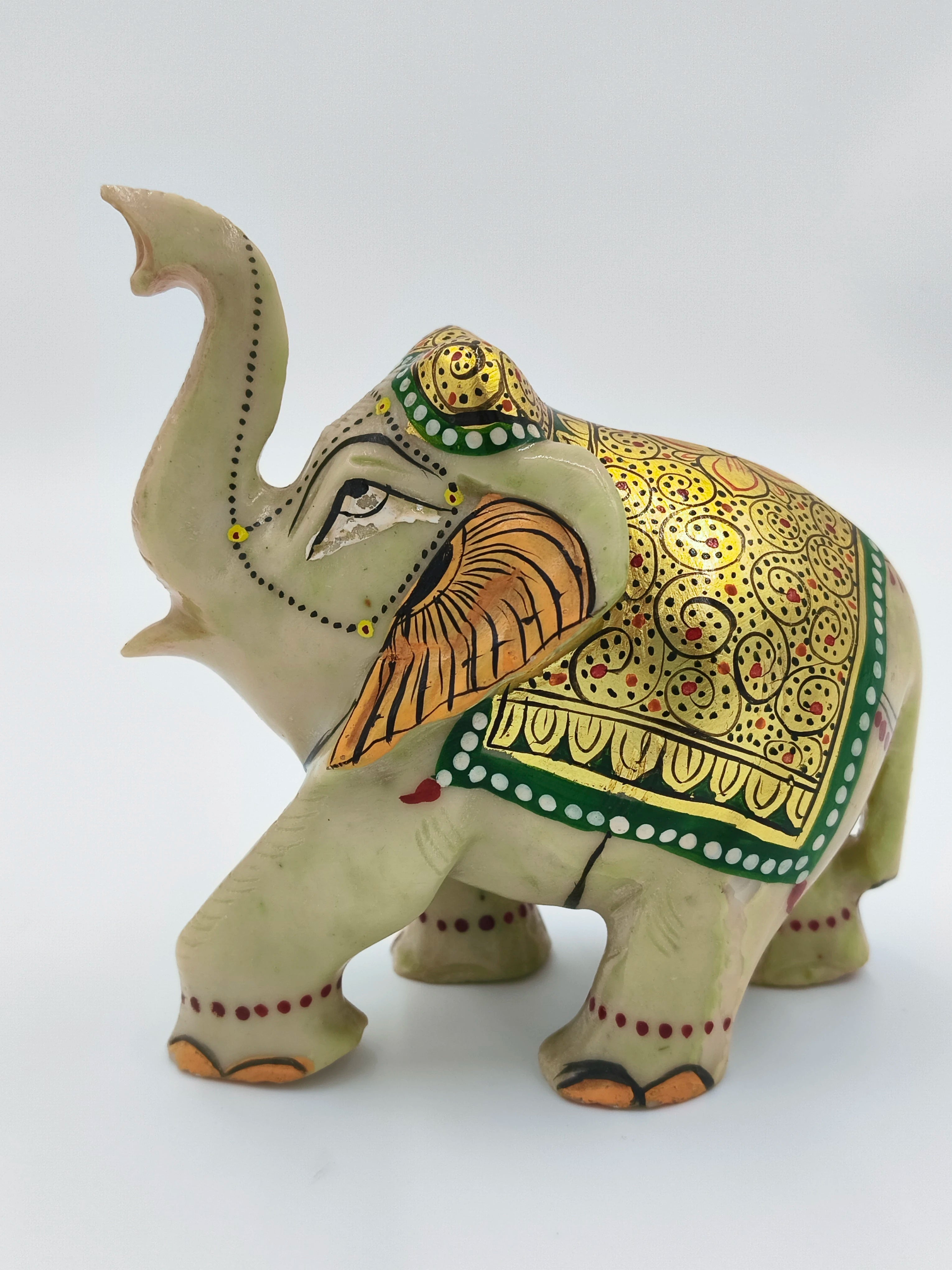 Hand-painted serpentine elephant sculpture with ornate gold and green detailing