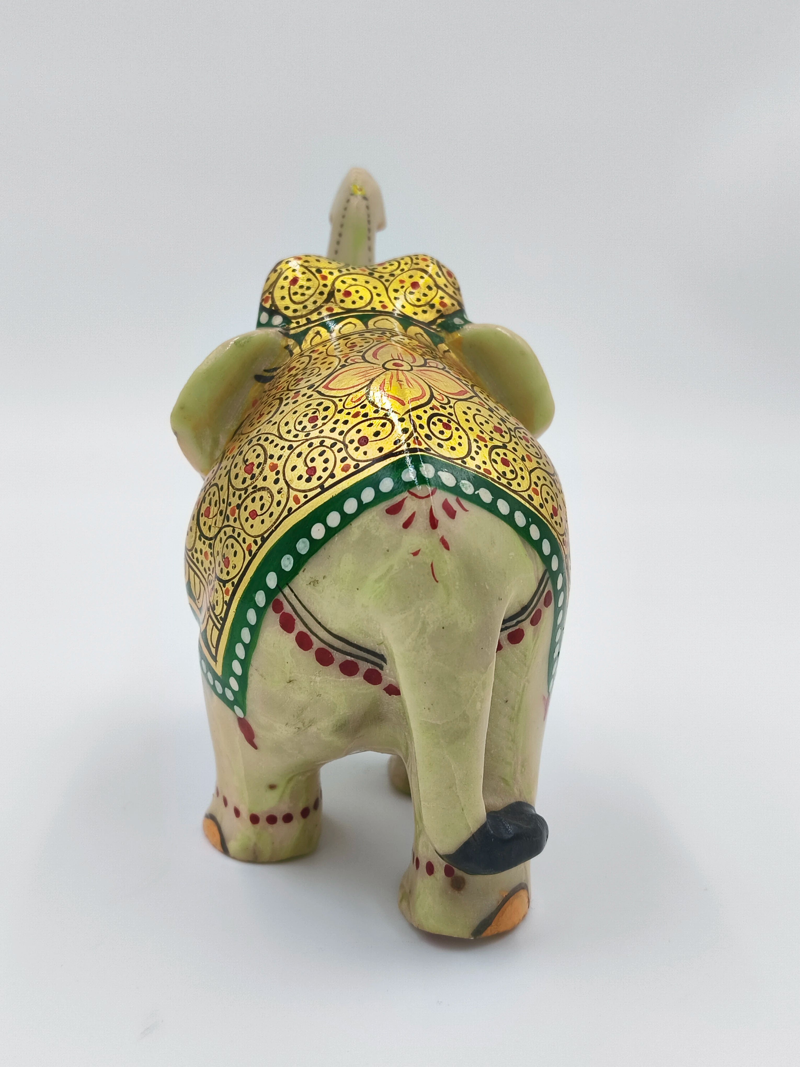 Back view of serpentine elephant figurine with detailed gold and red patterns