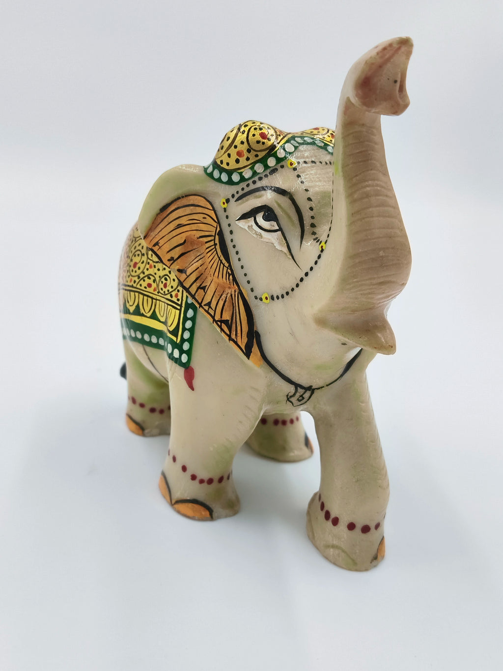 Hand-painted serpentine elephant sculpture with green, yellow, and orange decorative patterns