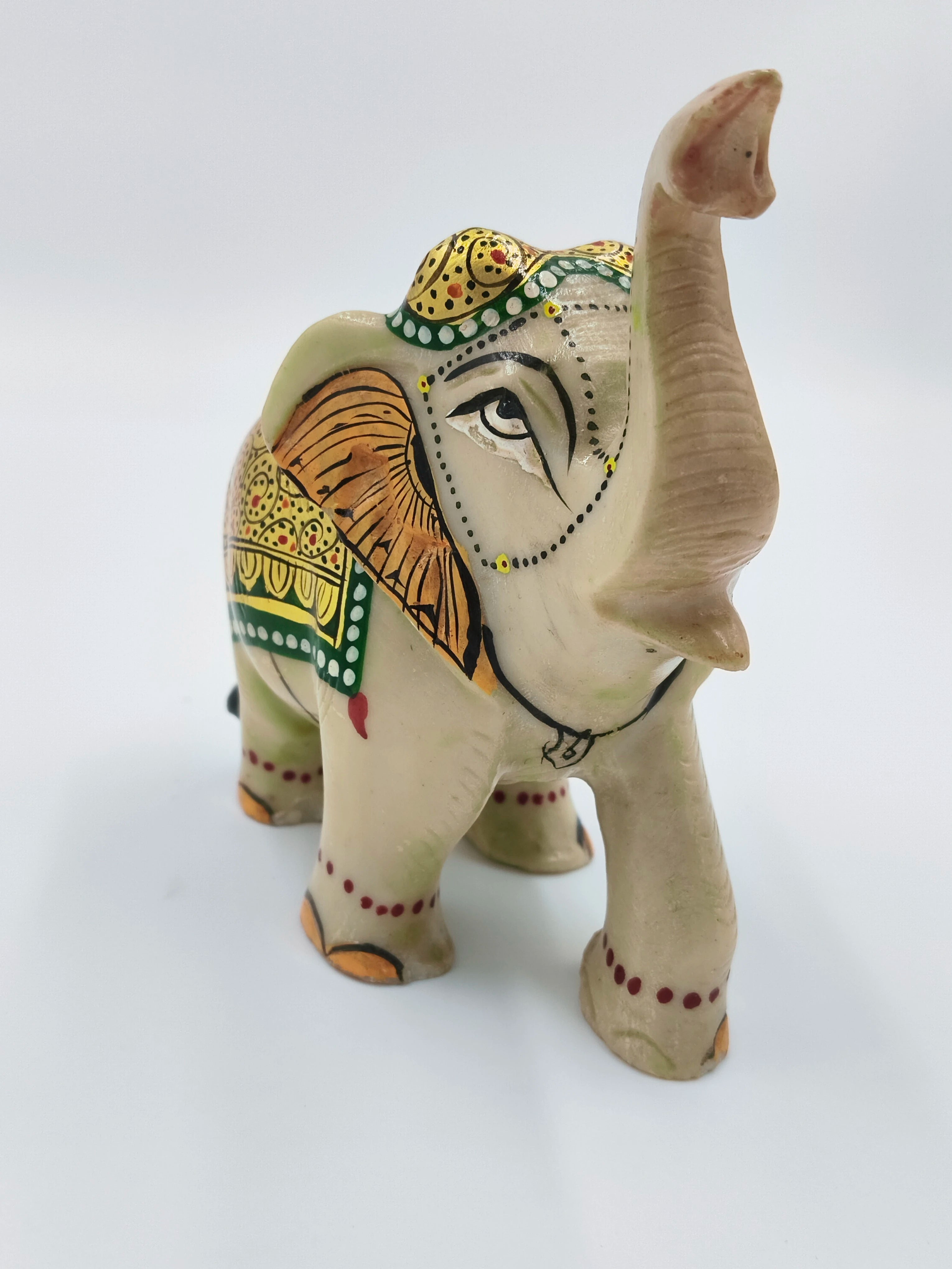 Hand-painted serpentine elephant sculpture with green, yellow, and orange decorative patterns