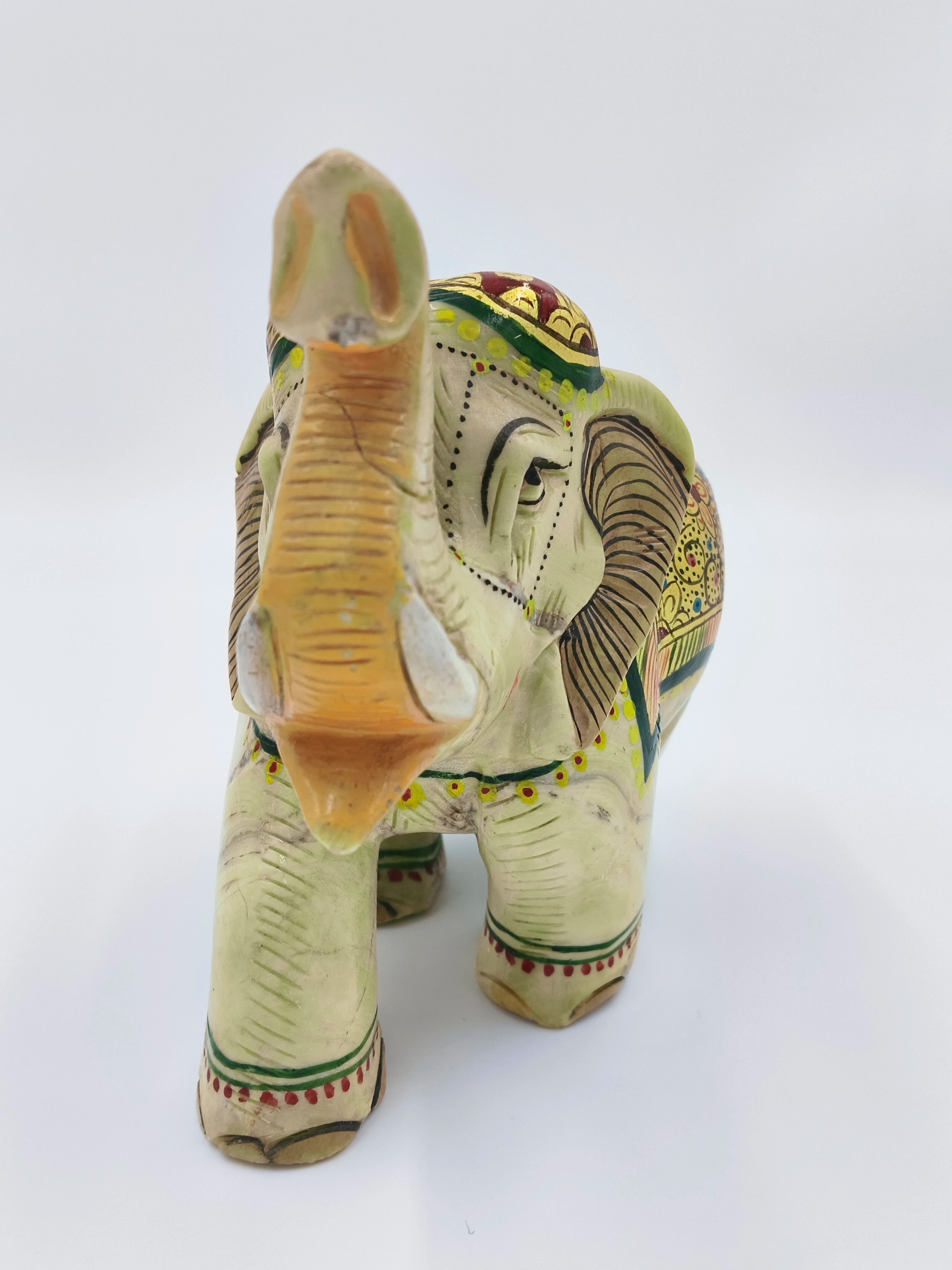 Front view of a hand-painted serpentine elephant sculpture with decorative patterns