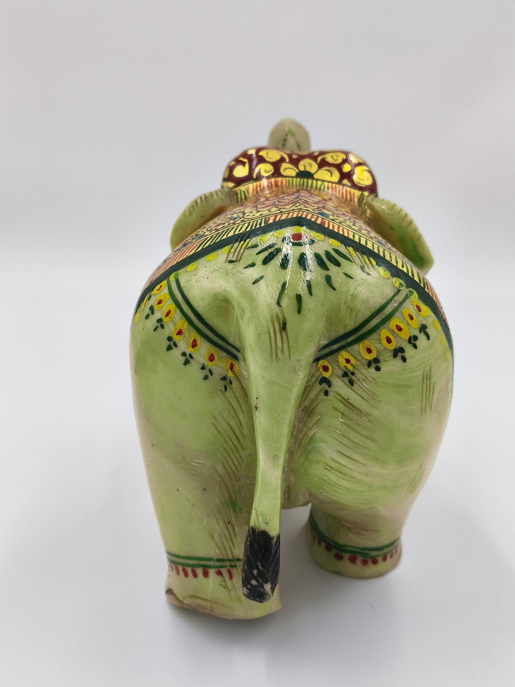 Rear view of serpentine elephant sculpture with floral patterns