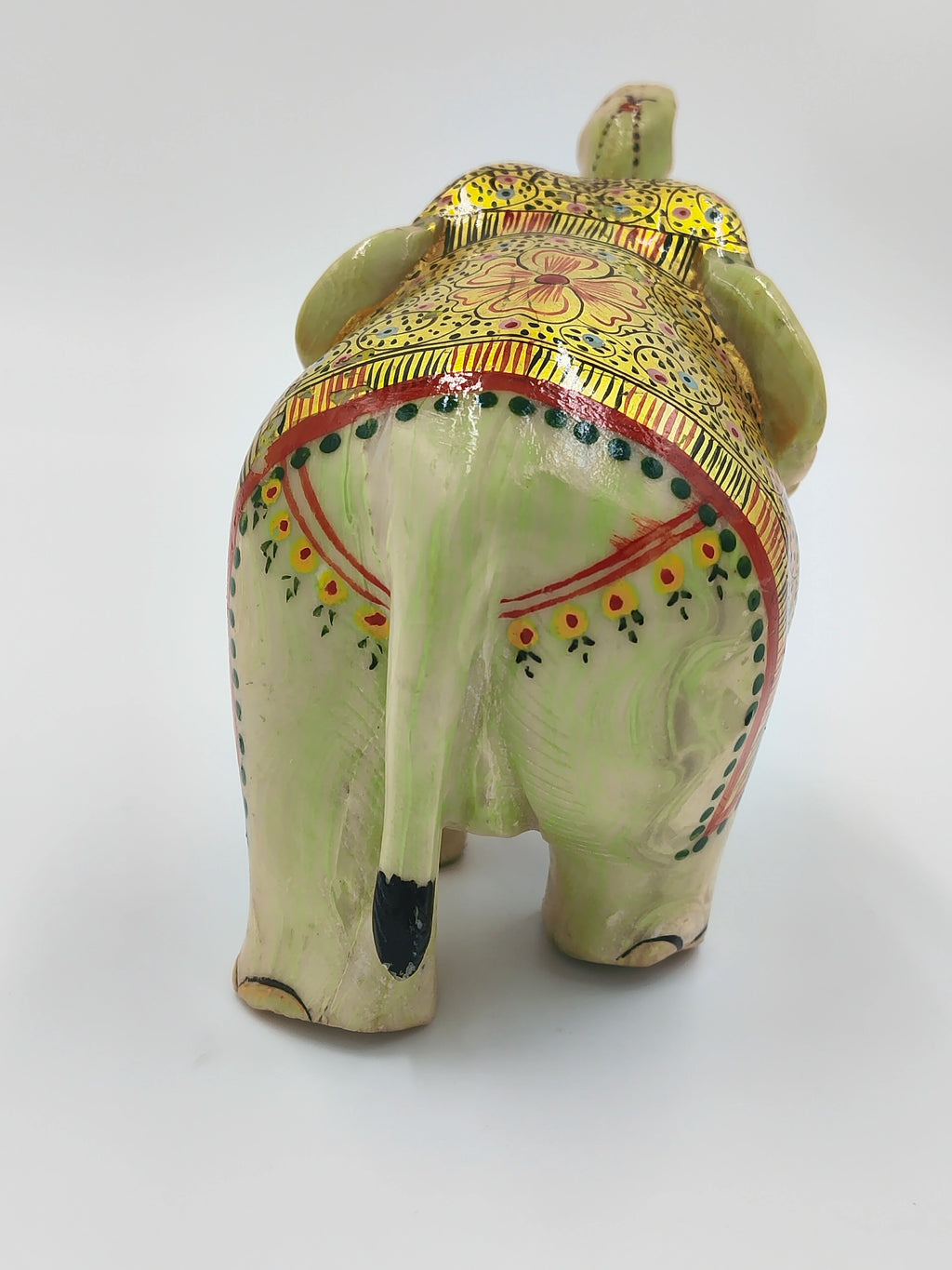 Back view of small serpentine elephant sculpture with decorative paint