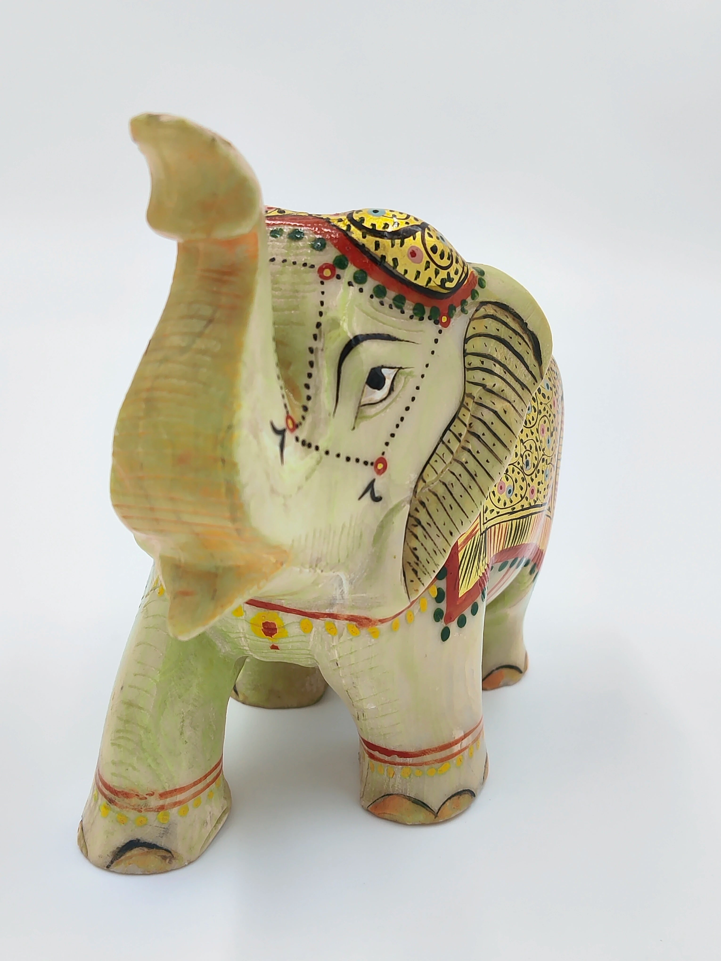 Small serpentine elephant sculpture with painted decorative patterns, front view