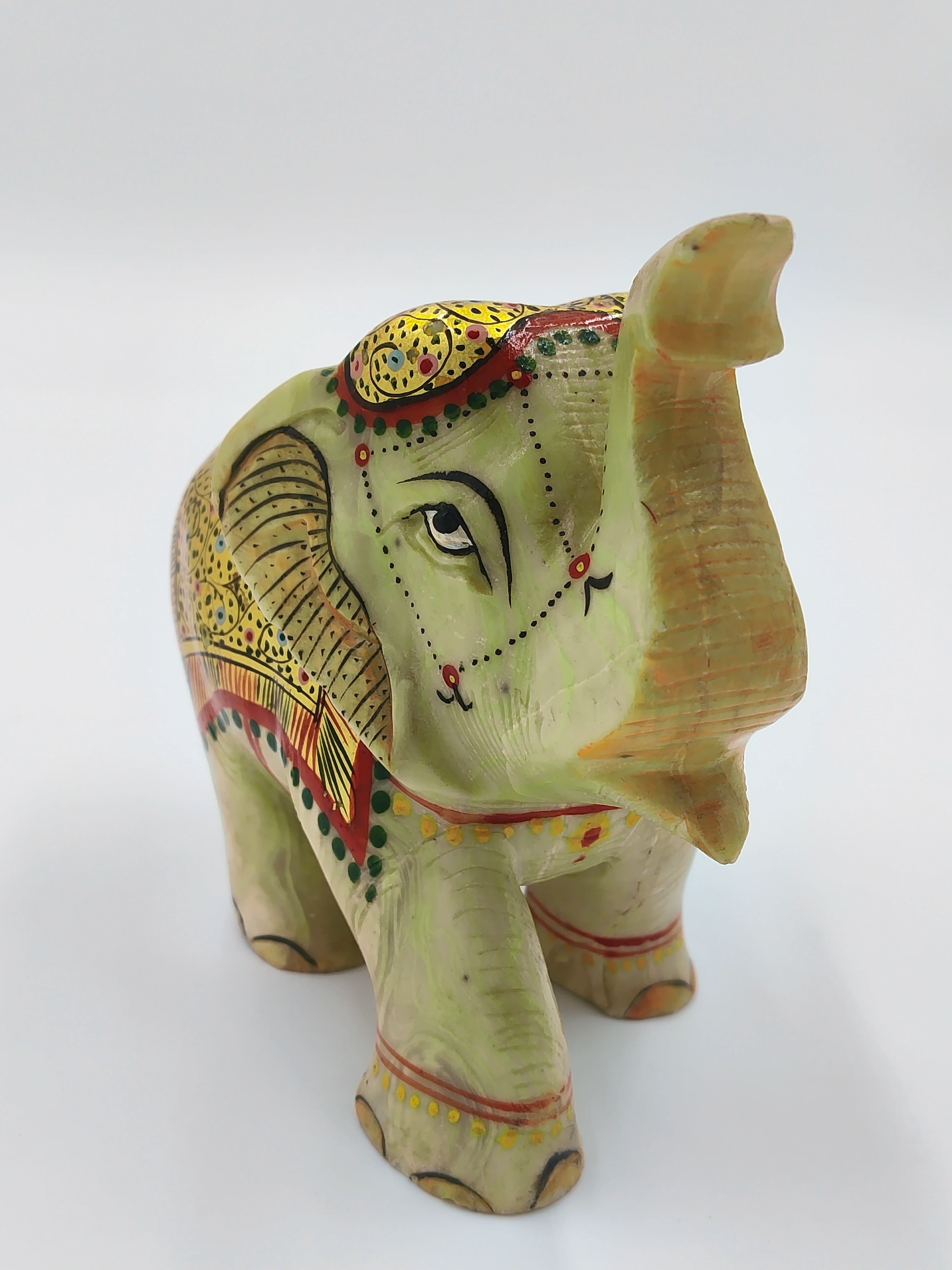 Hand-painted serpentine elephant sculpture with raised trunk and intricate yellow and red details